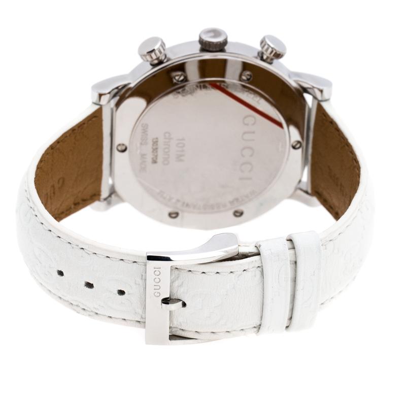 This elegant Gucci watch features a white mother of pearl dial with stud hour markers, two subdials and three hands. The 44 MM stainless steel case, adorned with a G-shaped bezel, is held by leather straps which are further equipped with engraved