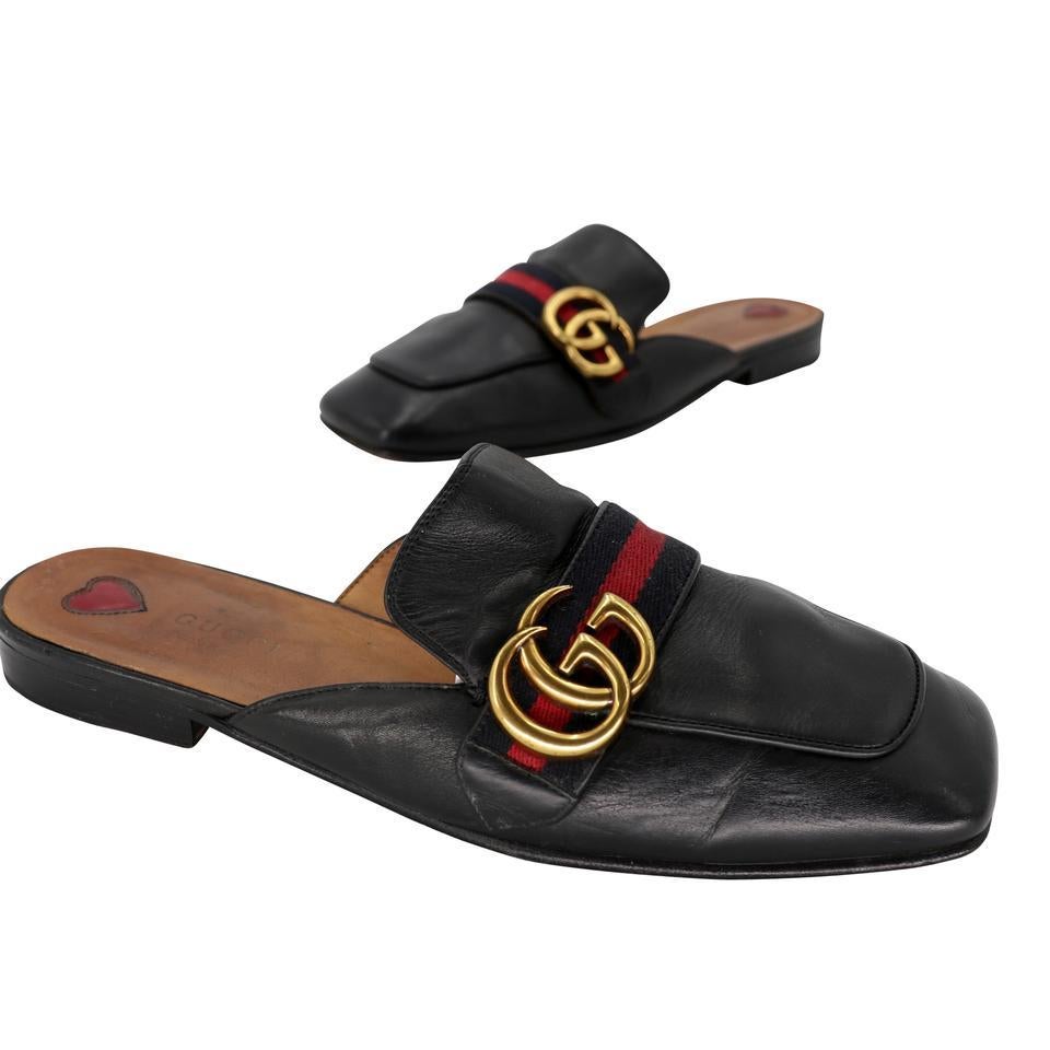 Slip into these comfortable and fashionable mules from Gucci. Featuring black color leather with the classic gold-tone Bamboo horse bit buckle and signature web detail. These mules are a take on the classic Gucci loafer. The soles have scuffing and