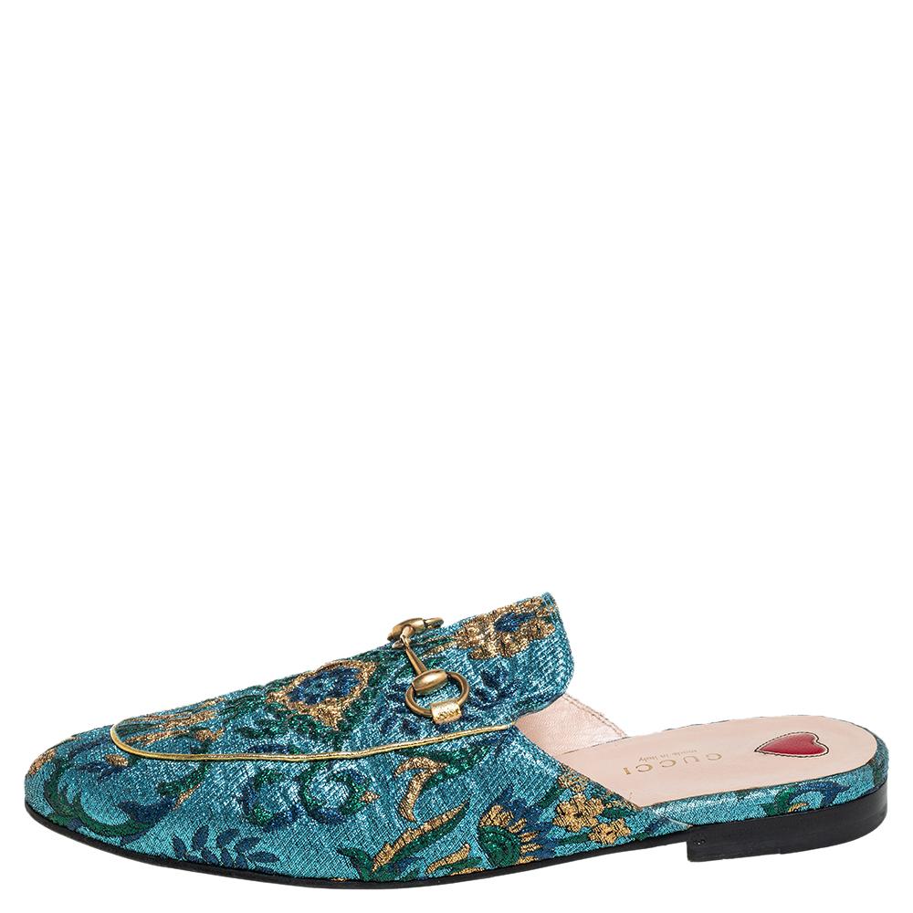 These Gucci Princetown mules are a fresh update on the perennially chic Gucci loafers. They are enhanced by the signature Horsebit hardware motifs that have defined the Gucci collection since the very beginning. Featuring a brocade fabric body,
