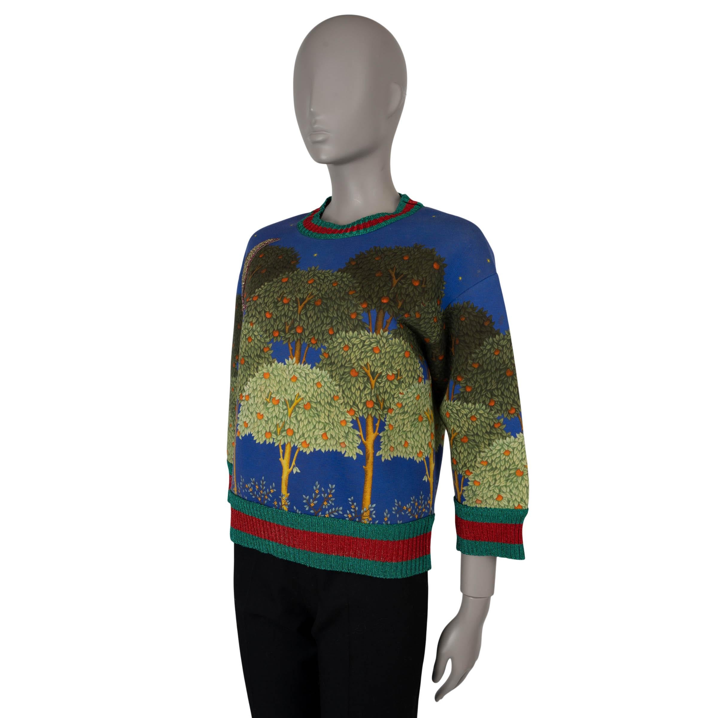 This 100% authentic Gucci sweater is crafted from blue and green cotton (100%) and features the bold Night Garden print. The design is enhanced by a crystal-embellished moon, a classic crewneck, and lurex green-red web trims, adding a touch of