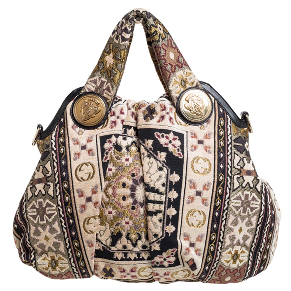 This Gucci hobo is built for everyday use. Crafted from tapestry fabric, it has a multicolored exterior and two handles, and intricate embroidery that exudes a bohemian charm. The nylon insides are sized well and the bag is complete with the