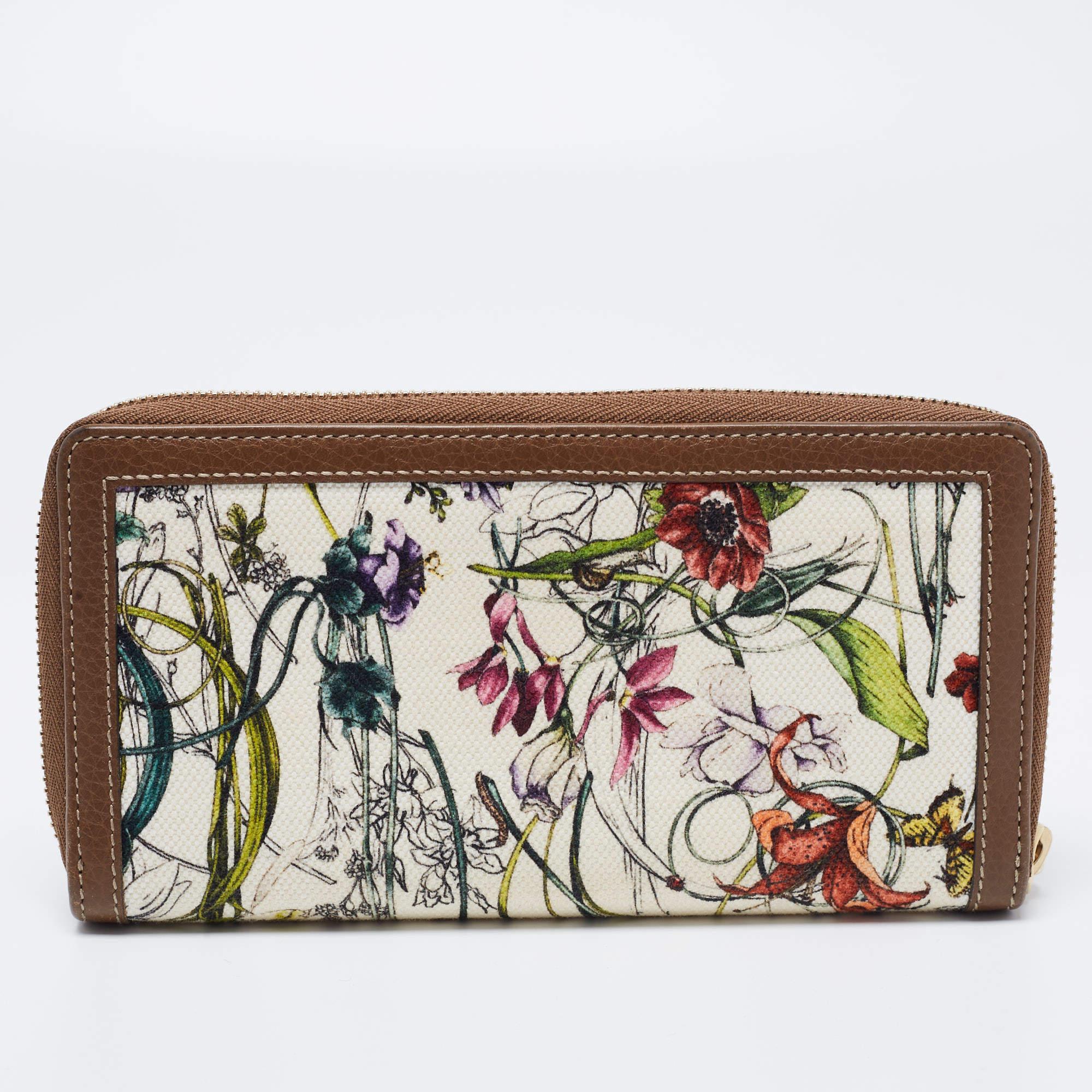 Infused with striking elements, this Gucci wallet will be your most preferred companion. It is created from canvas and leather with a beautiful floral print decorating its exterior, and it is adorned with gold-tone accents. Lined with leather and