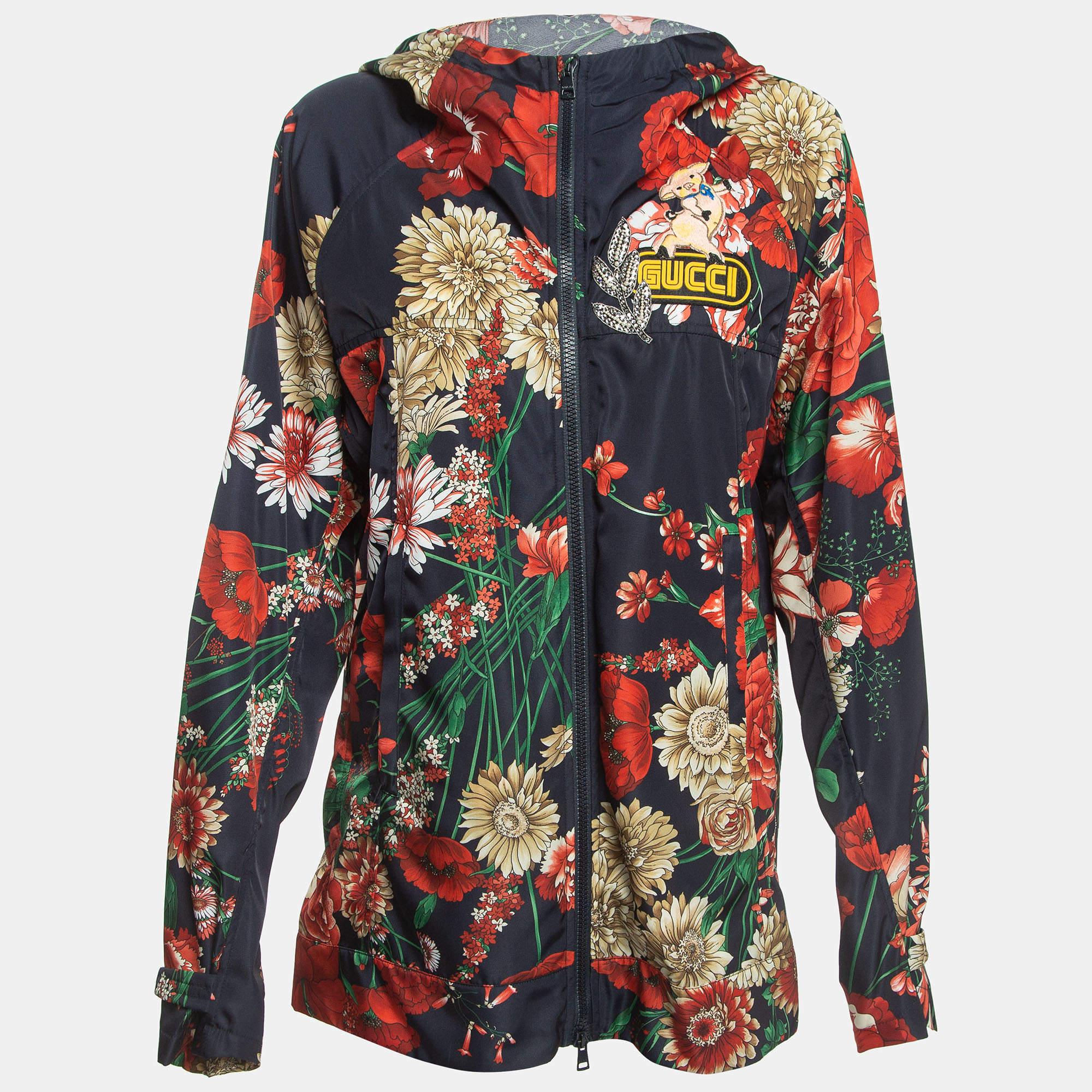 The Gucci jacket is a vibrant and stylish outerwear piece. Crafted from high-quality nylon, it features a striking floral print design with intricate applique detailing, complete with a cozy hood for added comfort and flair.

