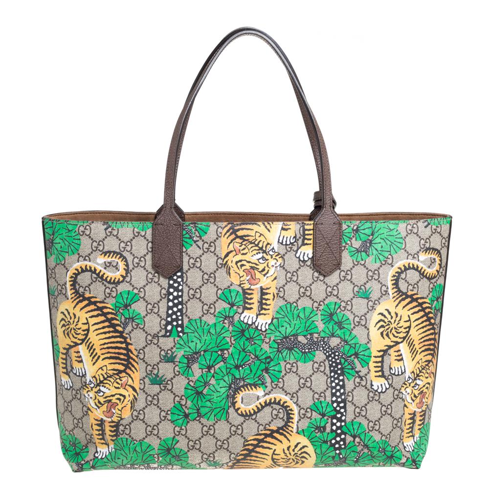 A creation that is both highly functional and appealing is this tote by Gucci. Crafted from GG Supreme coated canvas and leather, this tote has Bengal Tiger prints and is held by dual handles. It is complete with a spacious interior meant to hold