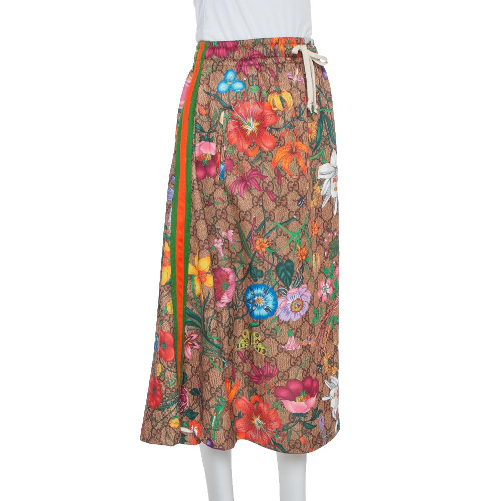 Make room in your closet for this creation from the house of Gucci. Designed for a fashionable look, this midi skirt is covered with flora prints over the brand's signature monogram. This skirt has a flared shape and an elasticized