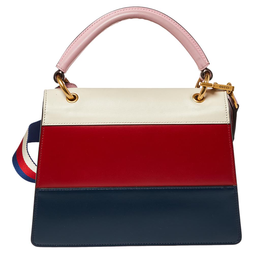 Die Queen Margaret Tasche aus dem Hause Gucci ist eine großartige Kombination aus Brillanz und zeitlosem Stil. Die Ledertasche mit oberem Griff:: die die charakteristischen Elemente in vollem Licht zeigt:: hat eine verzierte Klappe:: einen oberen