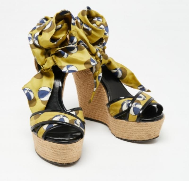 Stay comfortable throughout the day in these sandals by Gucci. Crafted to deliver drama and style, these stunning wedge sandals feature multicolored silk straps and ankle wrap detailing. They have an open toe silhouette, sturdy soles, and 15 cm