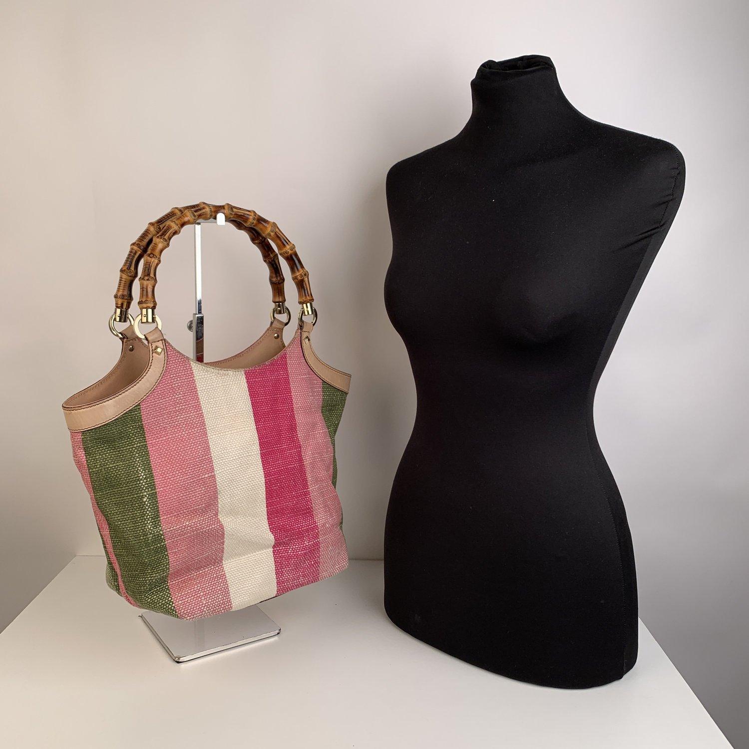 Beautiful GUCCI multicolor (Green, Pink, White and Light Pink) tote crafted in Baidera striped canvas. Light pink leather trimming. Gold colored hardware. Gucci's signature style double bamboo handles. Highlighted with studs. Fully lined with