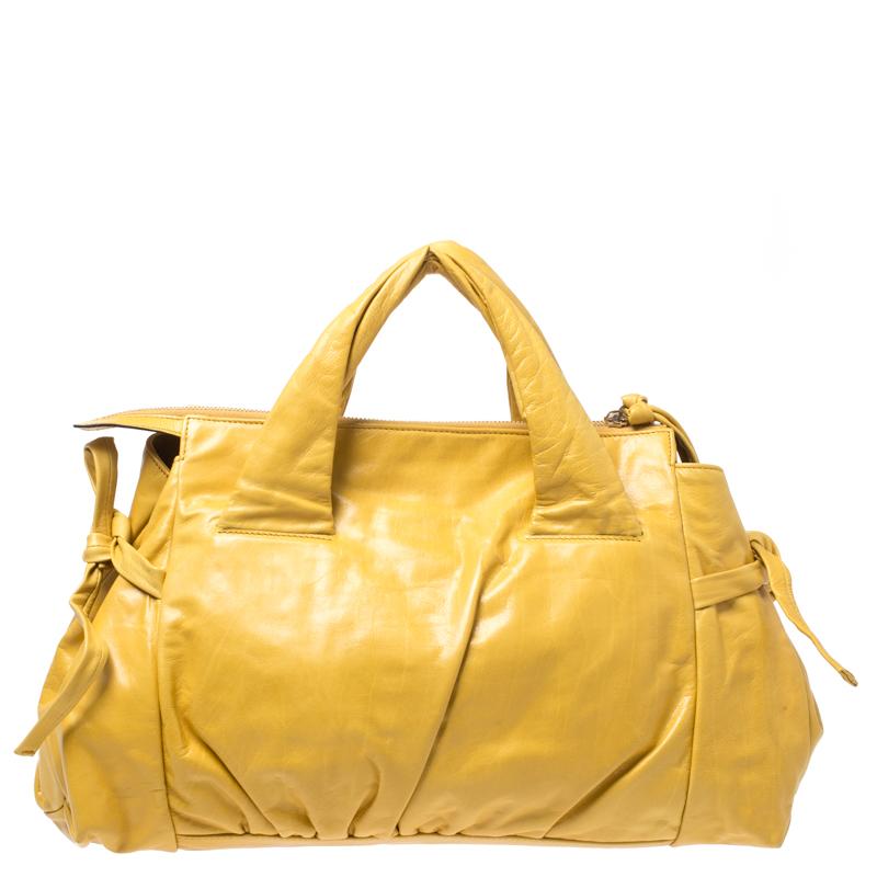 The meticulously designed details make this Hysteria Tote a must-have! Crafted in Italy and made from mustard leather with gold-tone hardware, it features double top handles. This tote is accented with a Gucci crest ornament at the centre and is