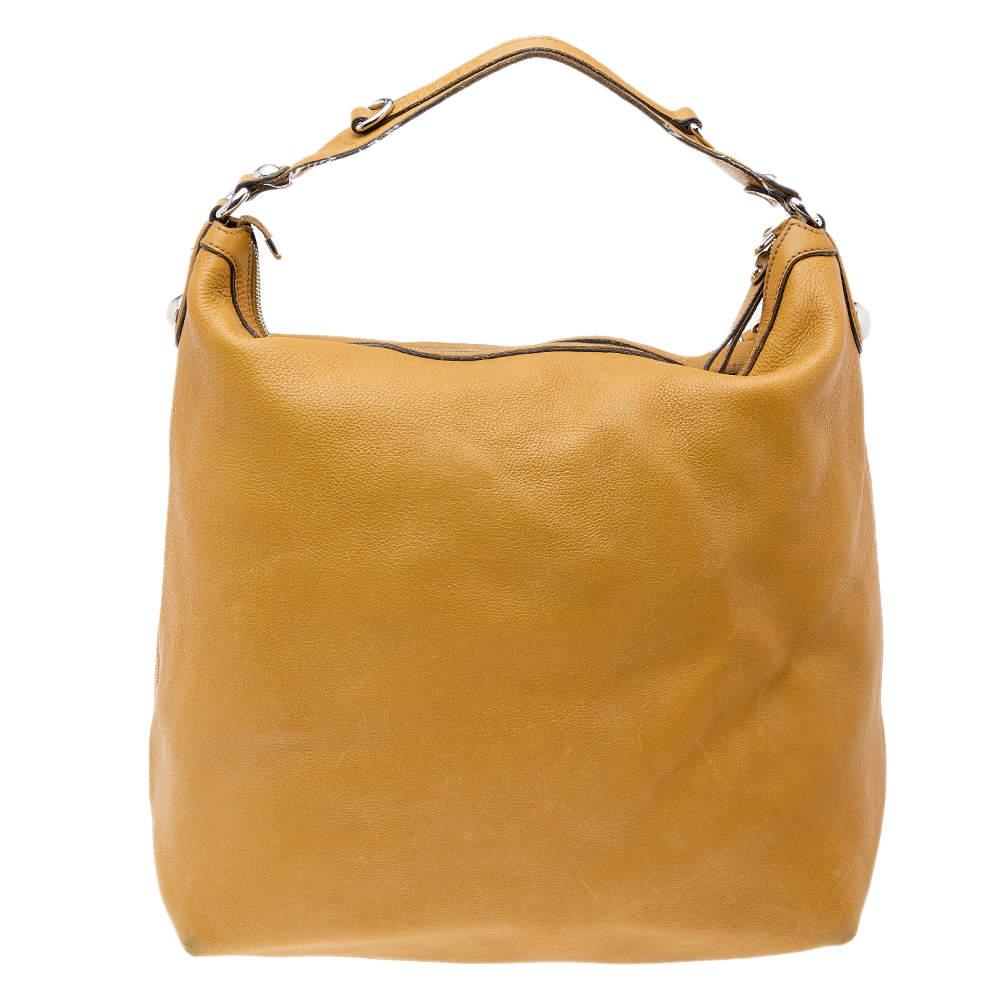 Ce superbe sac hobo de Gucci est impeccablement fabriqué à la main en Italie et ne manquera pas de s'ajouter à votre collection. Confectionné en cuir jaune, ce sac est doté de ferrures argentées et de détails Icone Bit. Le sac, doublé de toile, est