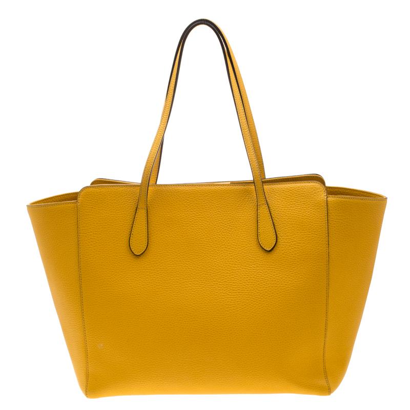 High in appeal and style, this tote is a Gucci creation. It has been crafted from leather in Italy and shaped to exude class and luxury. The bag comes with two handles, a spacious canvas interior, and the brand label on the front. This tote is ideal