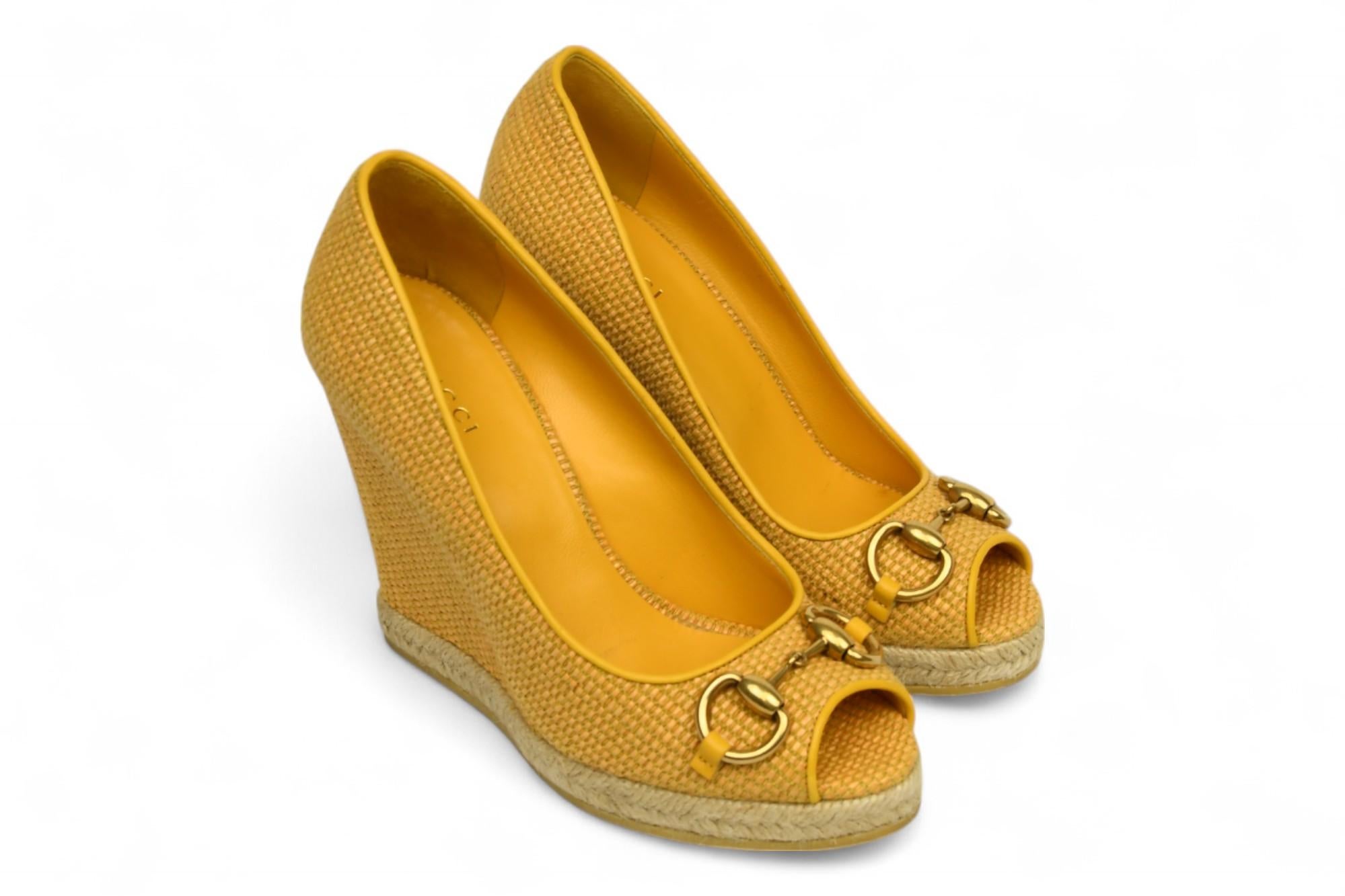 Gucci Zeppa Charlotte Horsebit in rafia senape con punta aperta

Aggiungi un tocco di colore al tuo guardaroba della stagione calda con queste zeppe Gucci Mustard Raffia Charlotte Horsebit Peep Toe. Realizzate con maestria in Italia, presentano una