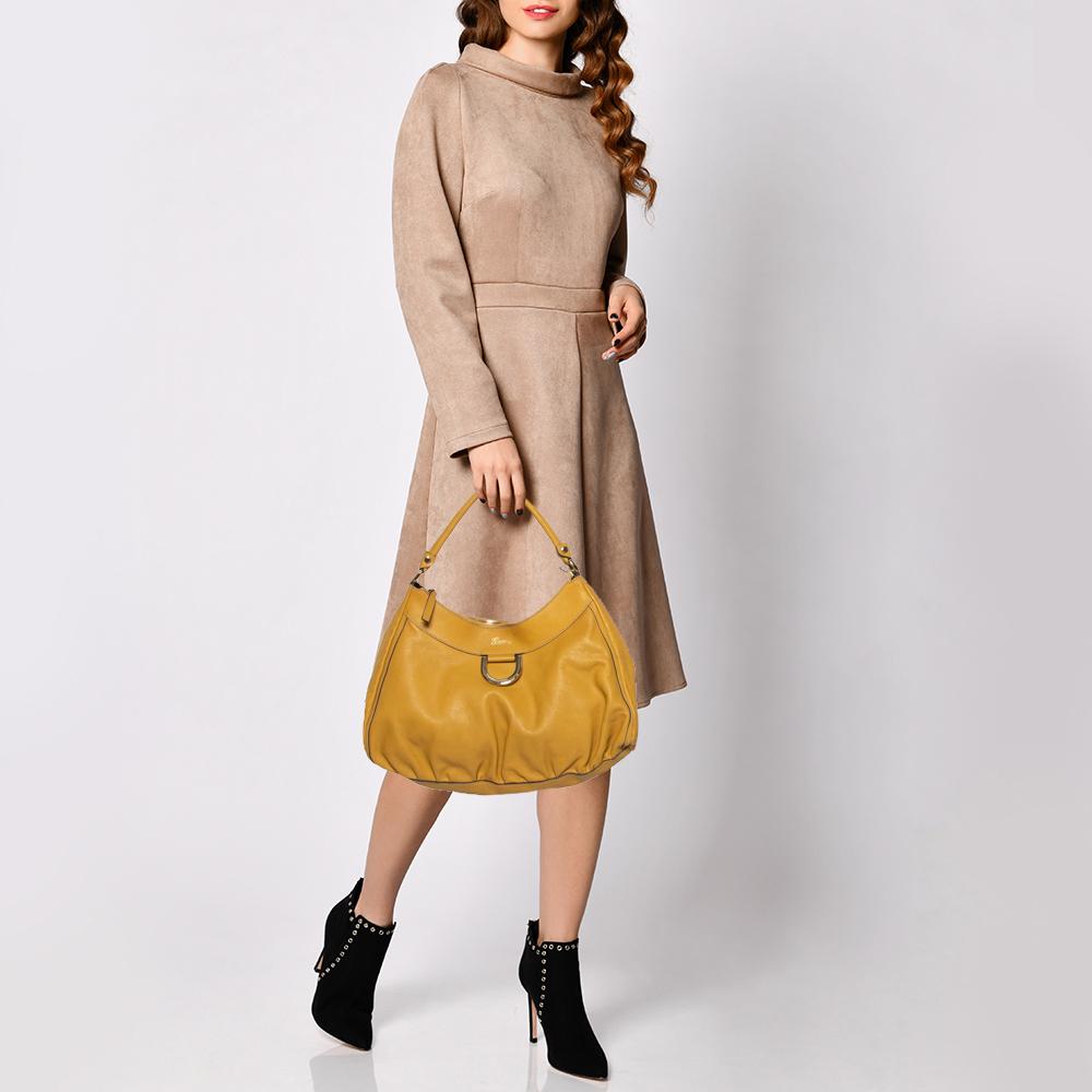 Gucci brings to you this amazing hobo that is smart and modern. Made in Italy, this mustard yellow hobo is crafted from canvas and leather trims and features a single handle and a D-shaped ring at the front. The top zip closure reveals a