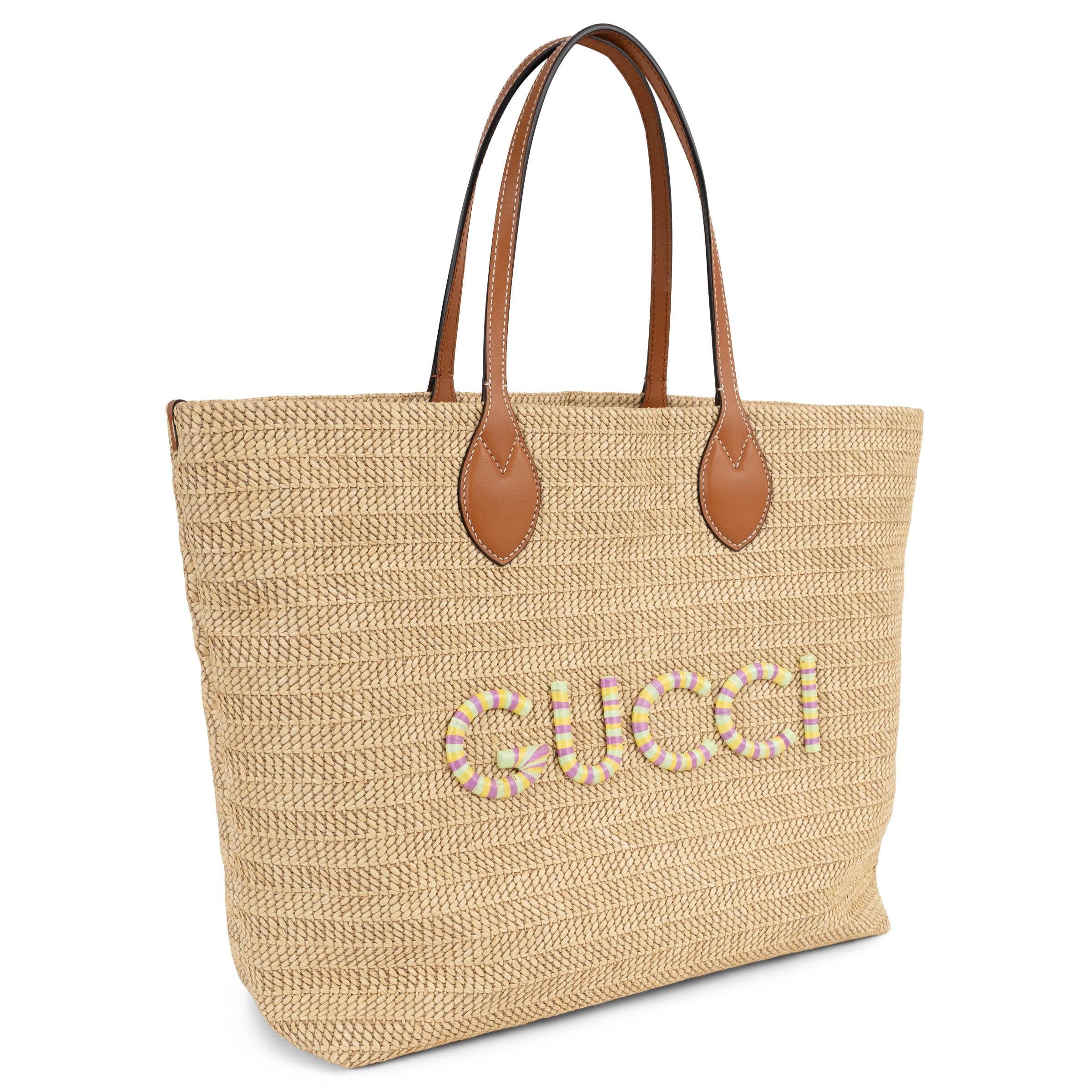 This 100% authentic Gucci medium tote is crafted in natural raffia and viscose for a relaxed straw-effect finish. It features smooth brown leather handles and trims, and a striped logo patch in pastel green, yellow, and pink straw, lending a soft