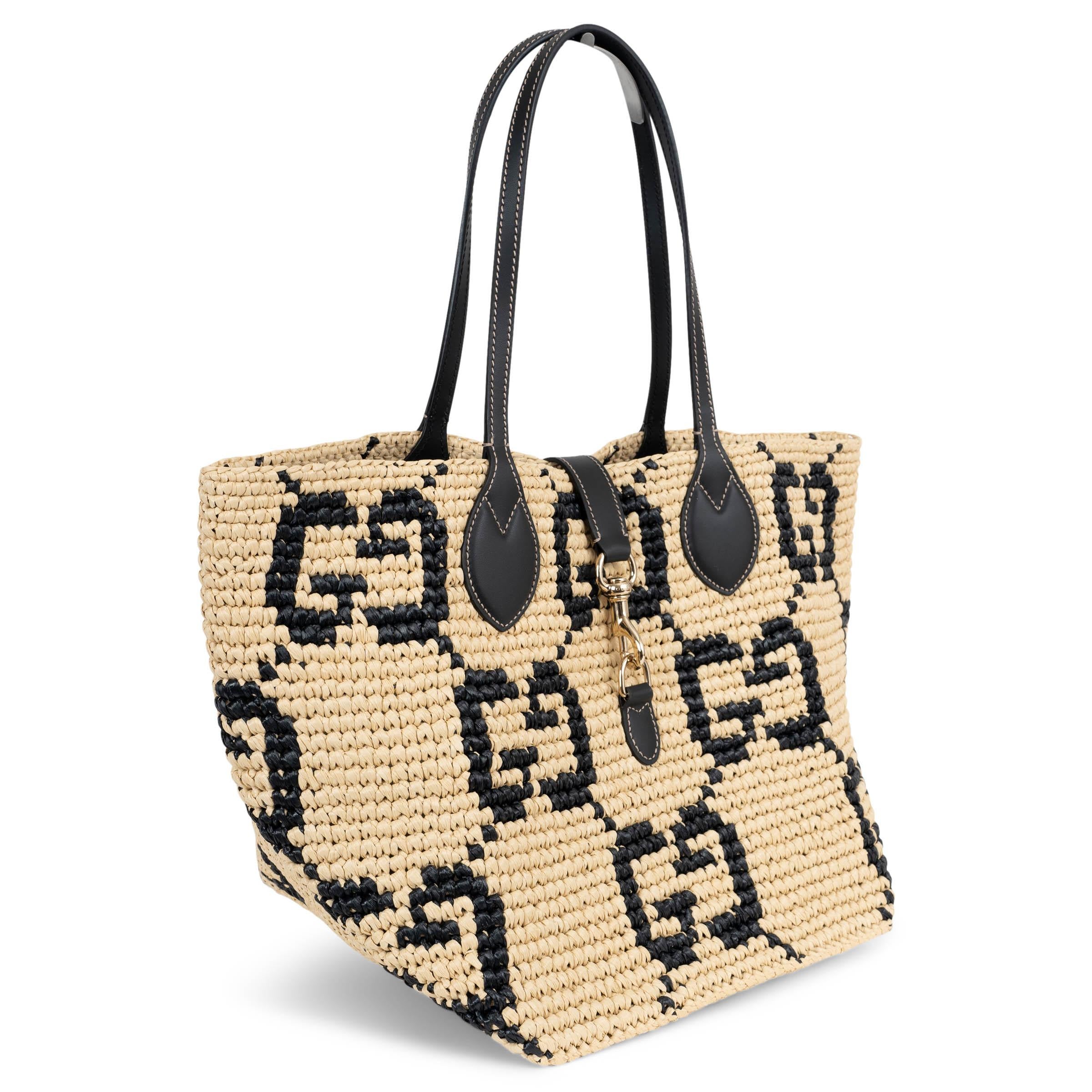 This 100% authentic Gucci Medium Tote is crafted in natural raffia-effect fabric with an all-over black GG pattern and black leather handles. It features a light gold-tone dog-hook closure at the front and comes unlined for a relaxed, airy