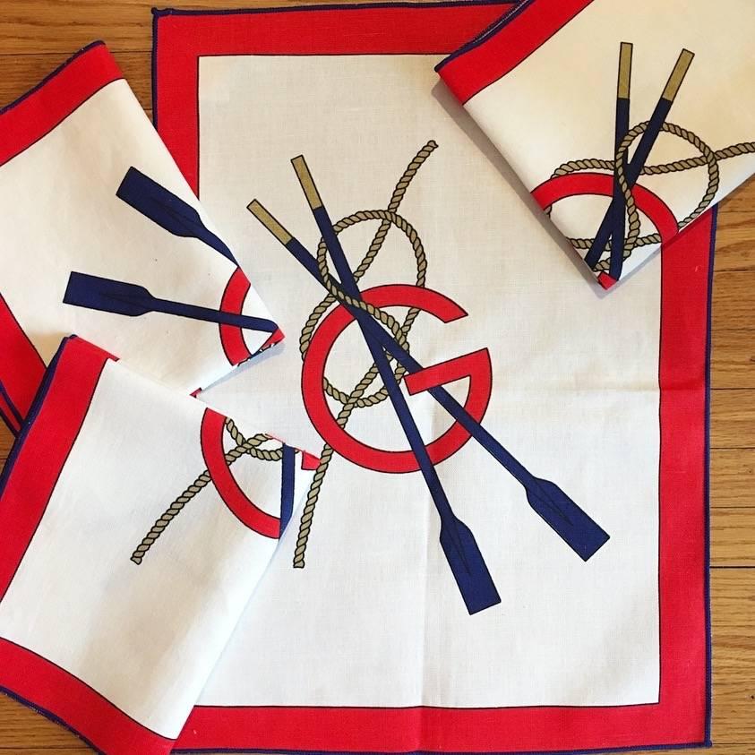 This is a fabulous set of four vintage Gucci cloth napkins. Each features a red Gucci 'G' in the center, two navy oars and nautical rope. They have red borders and are stitched around the edges with navy thread. They are made of 50% cotton and 50%