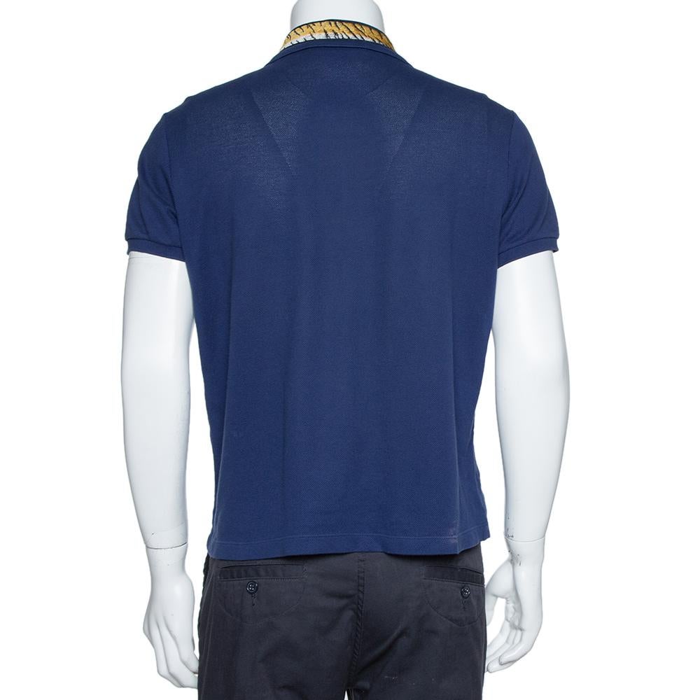 Dieses exklusive T-Shirt stammt aus dem Hause Gucci. Es ist aus einer Baumwollmischung gefertigt und in einem marineblauen Farbton gehalten. Der Kragen ist bestickt und zeigt das charakteristische Tigermotiv. Abgesehen von dem Statement-Kragen ist