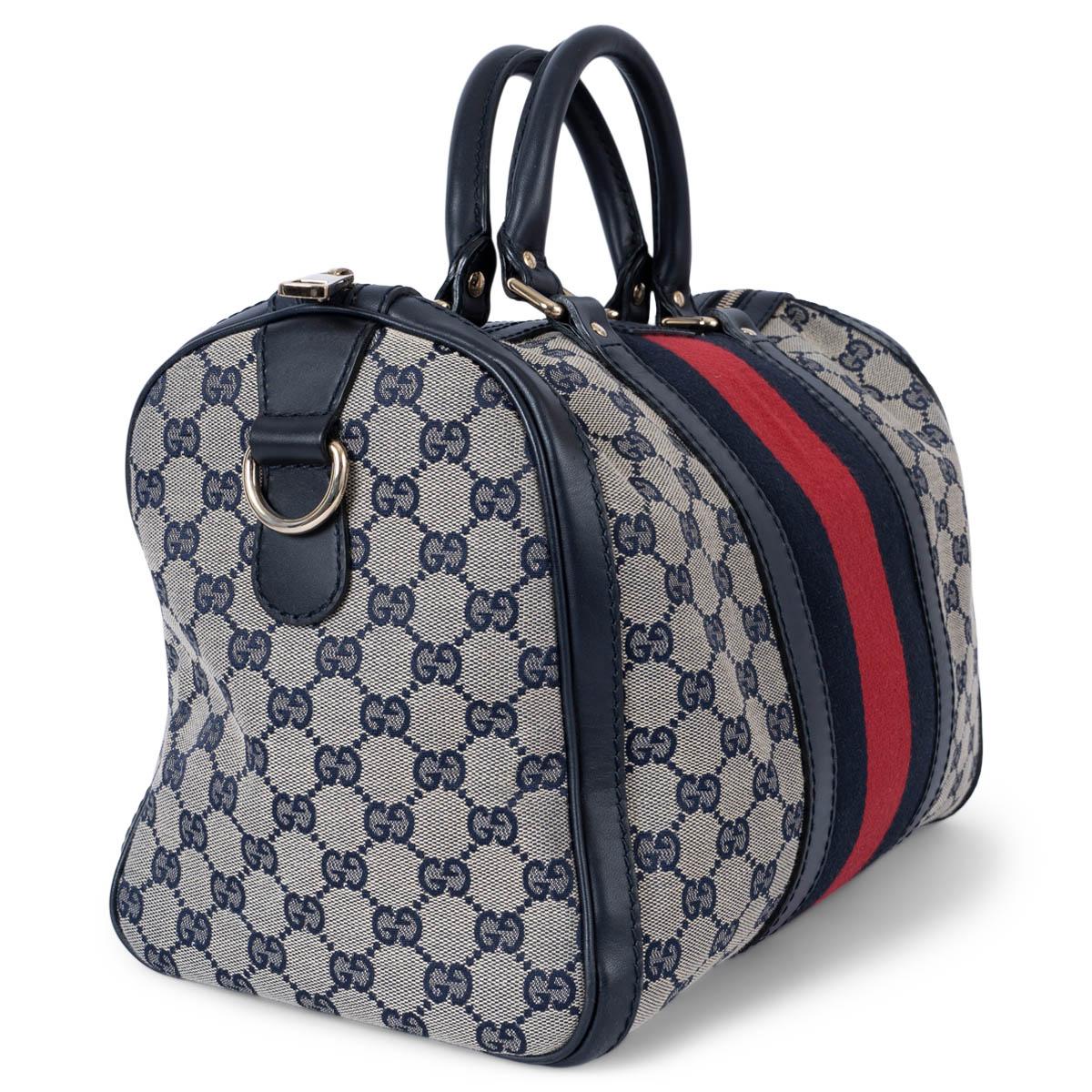 100% authentic Gucci Vinatge Boston bag in navy blue and ivory GG canvas with blue leather trim and classic red & blue Web stripe in the middle. The design features light gold-toned hardware and opens with a zipper on top. Lined in ivory canvas