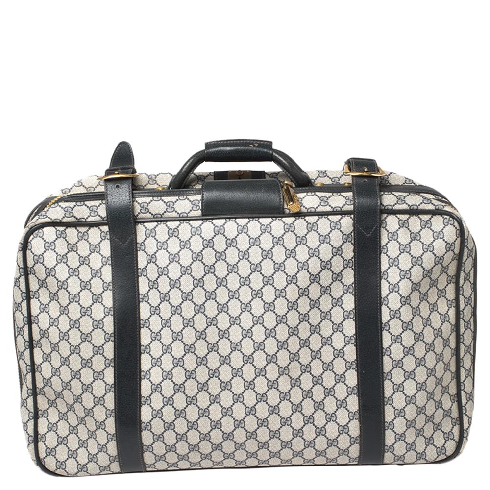 A vintage handheld suitcase by Gucci to elevate your traveling experience. It has been crafted from the brand's signature GG Supreme canvas and leather trims. Equipped with a top handle, belted straps, and a spacious interior lined with fabric, this