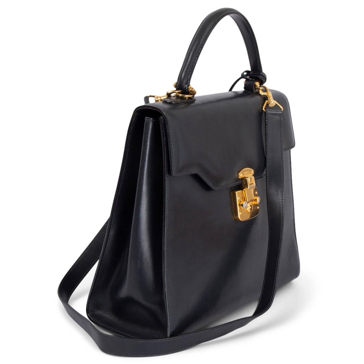 100% authentic Gucci Vintage Lady Lock top handle bag in navy blue featuring gold-tone hardware. Opens with a push-lock and a flap to a red lined leather interior with a zipper pocket against the back and two open pockets. Comes with a detachable