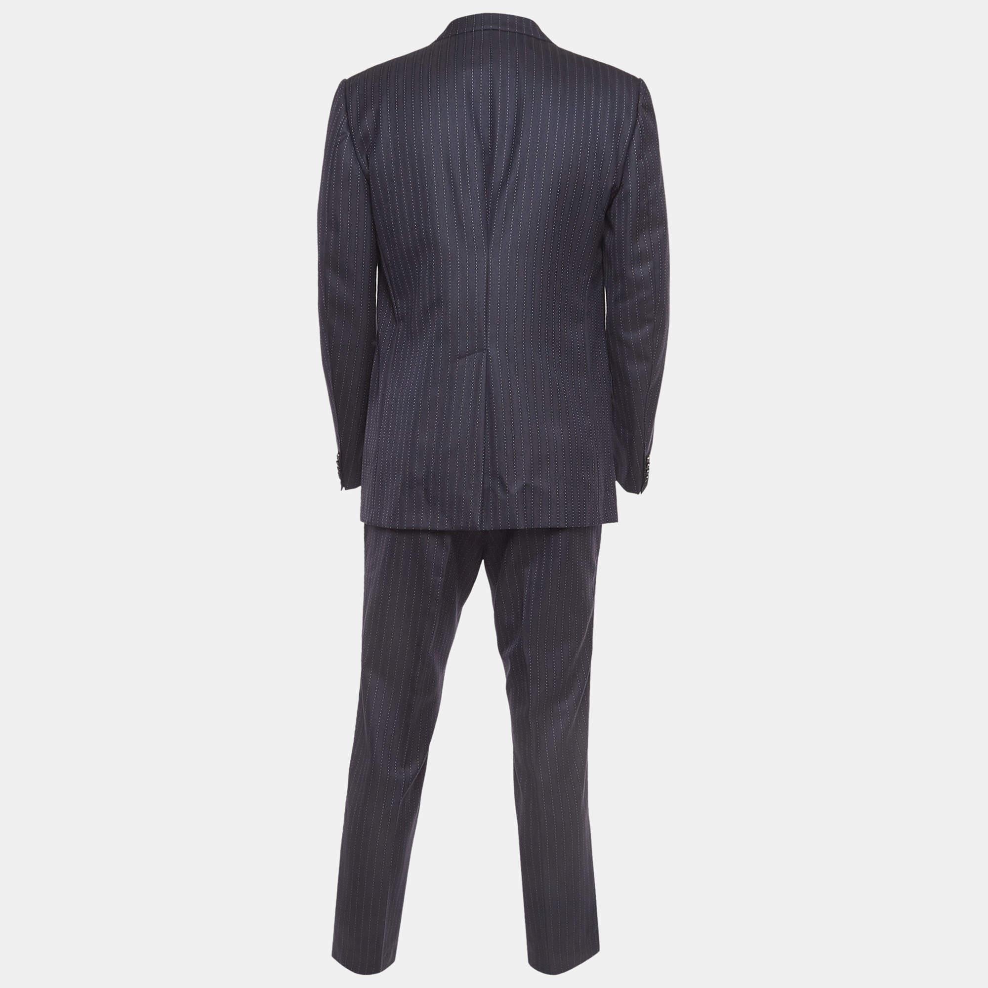 Crafted from luxurious navy blue pinstripe wool, this Gucci single-breasted suit exudes timeless elegance. Tailored to perfection, it features impeccable detailing and a sleek silhouette, embodying sophistication and refinement. Elevate your style