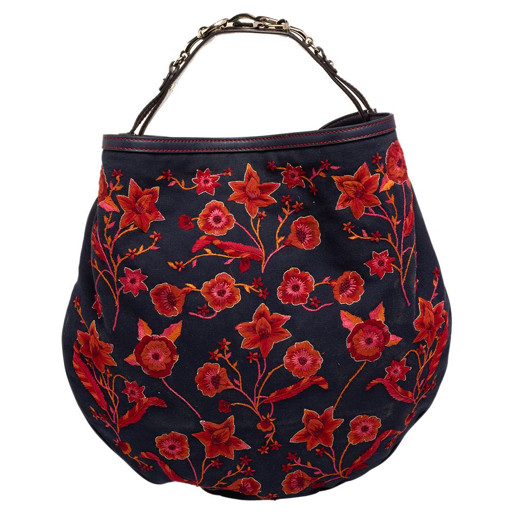 Add a special creation to your closet with this Wave hobo from Gucci. The bag is made of floral-embroidered canvas and held by a metal-decorated leather handle. The bag's spacious interior is lined with fabric.

