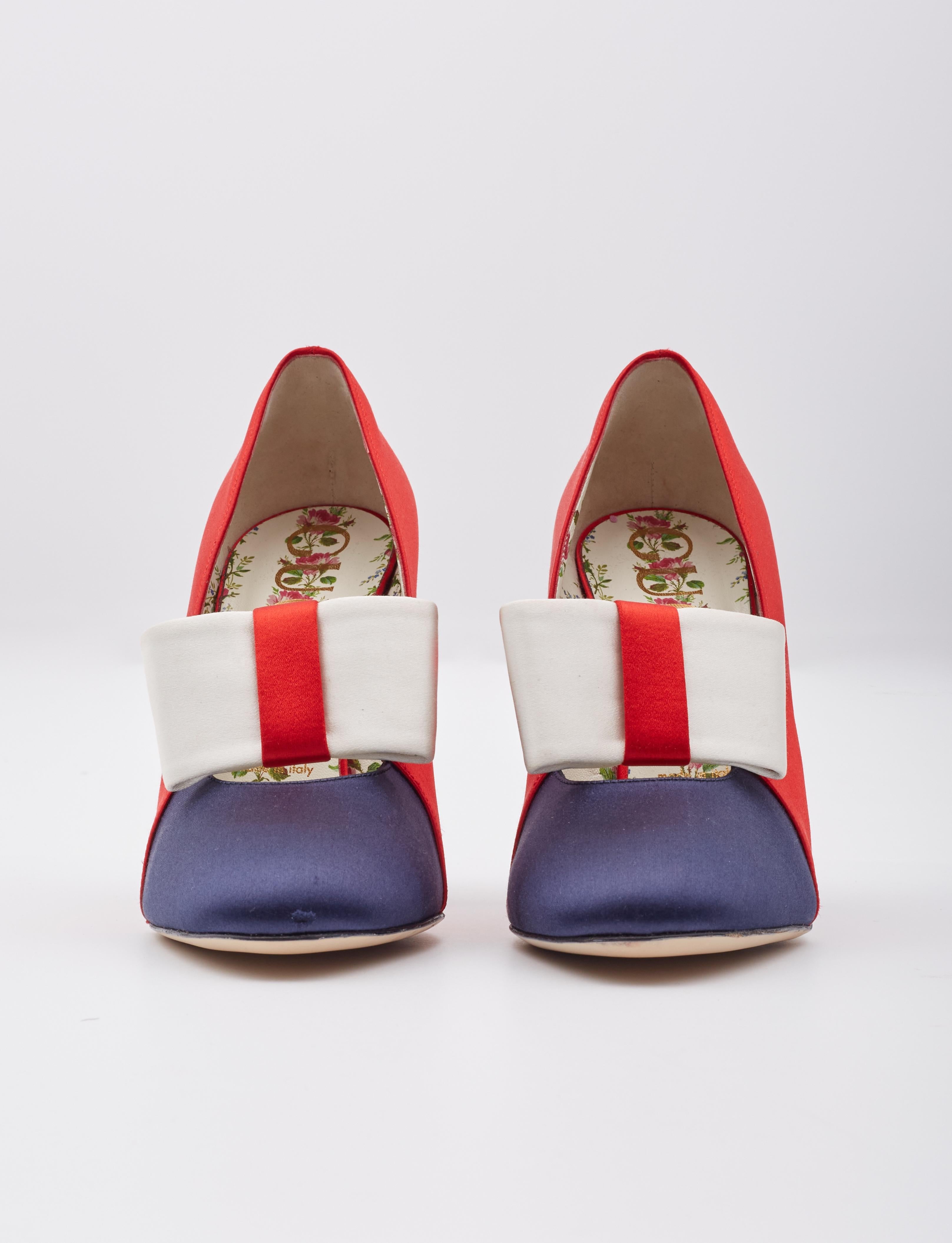 These bold pumps are made of red and blue satin with a large bow embellishment on the front. They feature faux pearl and gold spiked accents on a 4.5 inch wrapped heel, and a slightly rounded toe.

Color: Multicolor / red / navy / white
Materials: