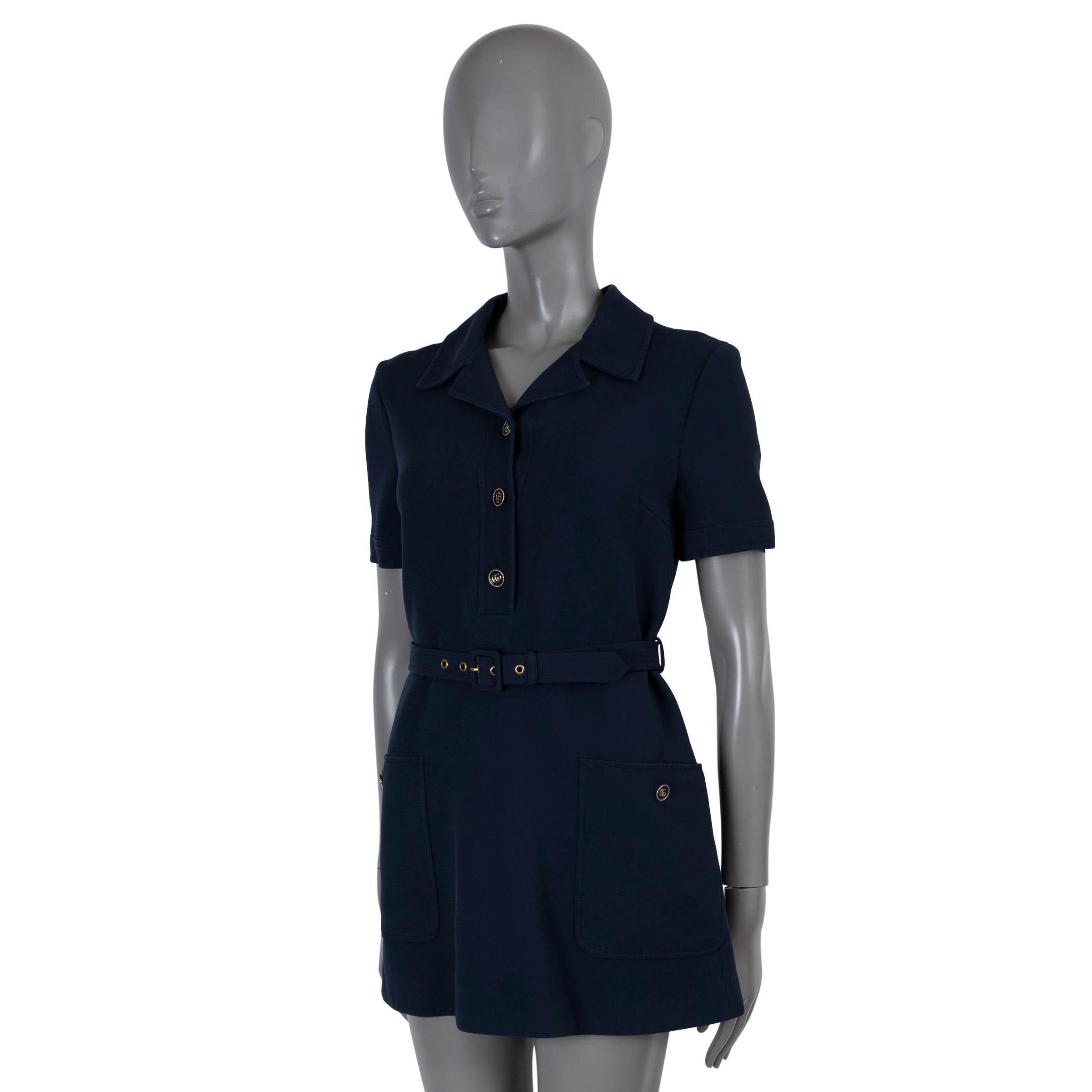100% authentic Gucci mini shirt dress in navy blue silk (53%) and wool (47%). Features peak lapels, short sleeves, two buttoned pockets at the waist and decorative buttons on the front. Opens with a concealed zipper in the back and fastens with a