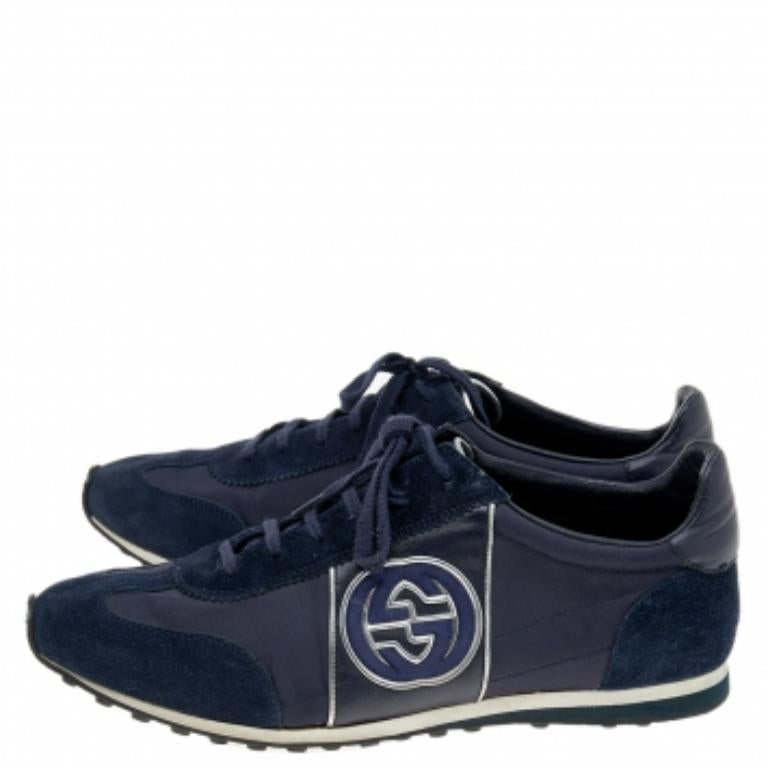 Conçues par la maison Gucci, ces baskets sont faites pour offrir un confort et un style incomparables. Elles sont réalisées en daim bleu marine et en nylon sur l'extérieur et présentent des lacets sur l'empeigne, un imprimé du logo GG sur le côté et
