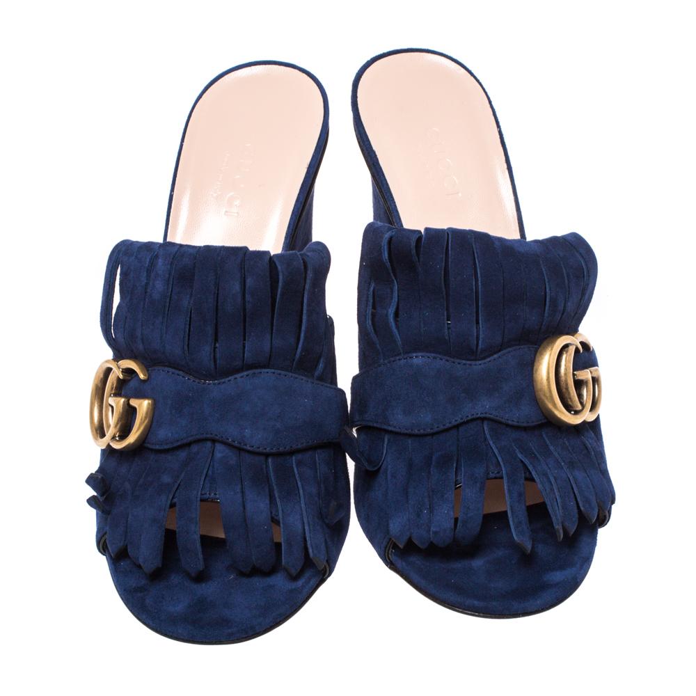 Pretty and easy to flaunt, this pair of Marmont sandals by Gucci is a stunner. They've been crafted from navy blue-hued suede and styled with folded fringes and the brand's signature GG logo in gold-tone on the uppers. Peep toes, 11 cm block heels,