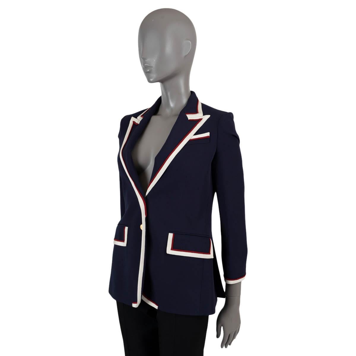 100% authentic Gucci stretch cady blazer in navy blue viscose (with 3% elastane). Features white and red grosgrain trim, peak lapels, buttoned cuffs and two flap pockets. Closes with two gold-tone buttons on the front and is lined in printed silk