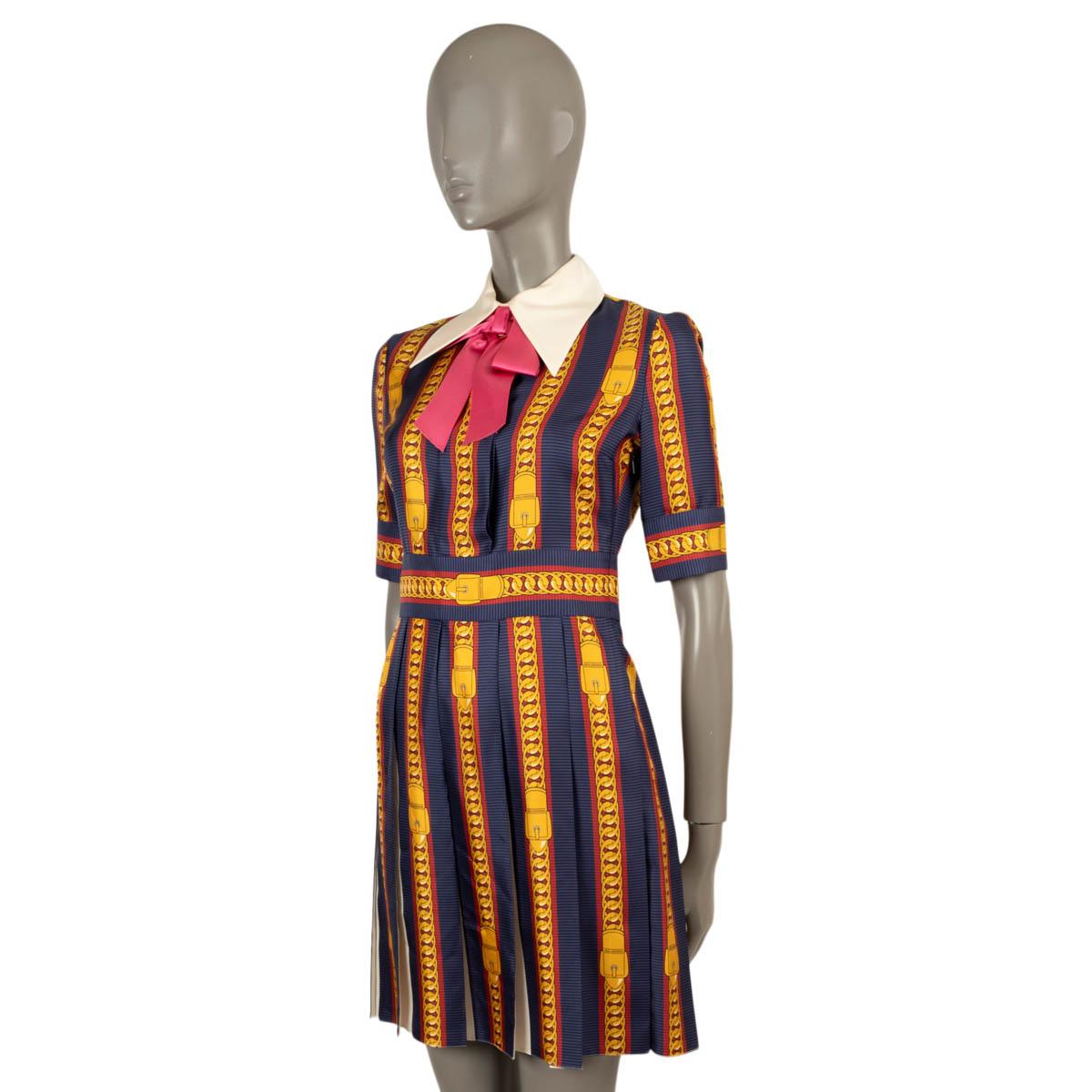 100% authentic Gucci short sleeve dress in navy blue silk twill (100%) with Sylvie Chain print in gold, black and red. Features a white collar with pink bow. Closes with a concealed zipper on the side. Unlined. Has been worn and is in excellent