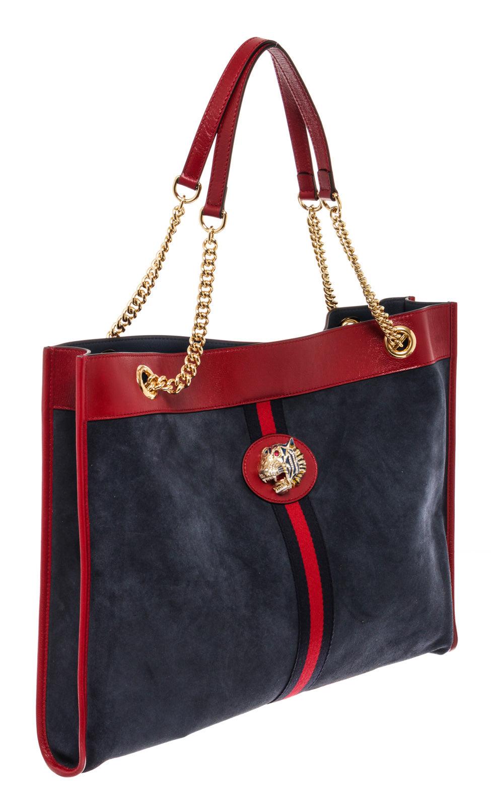 Navy blue suede and red leather Gucci Large Suede Rajah tote bag with gold-tone hardware, dual chain-link shoulder straps with leather shoulder guards, crystal-embellished lion head spur adornment at front face, tonal leather lining and open top.

