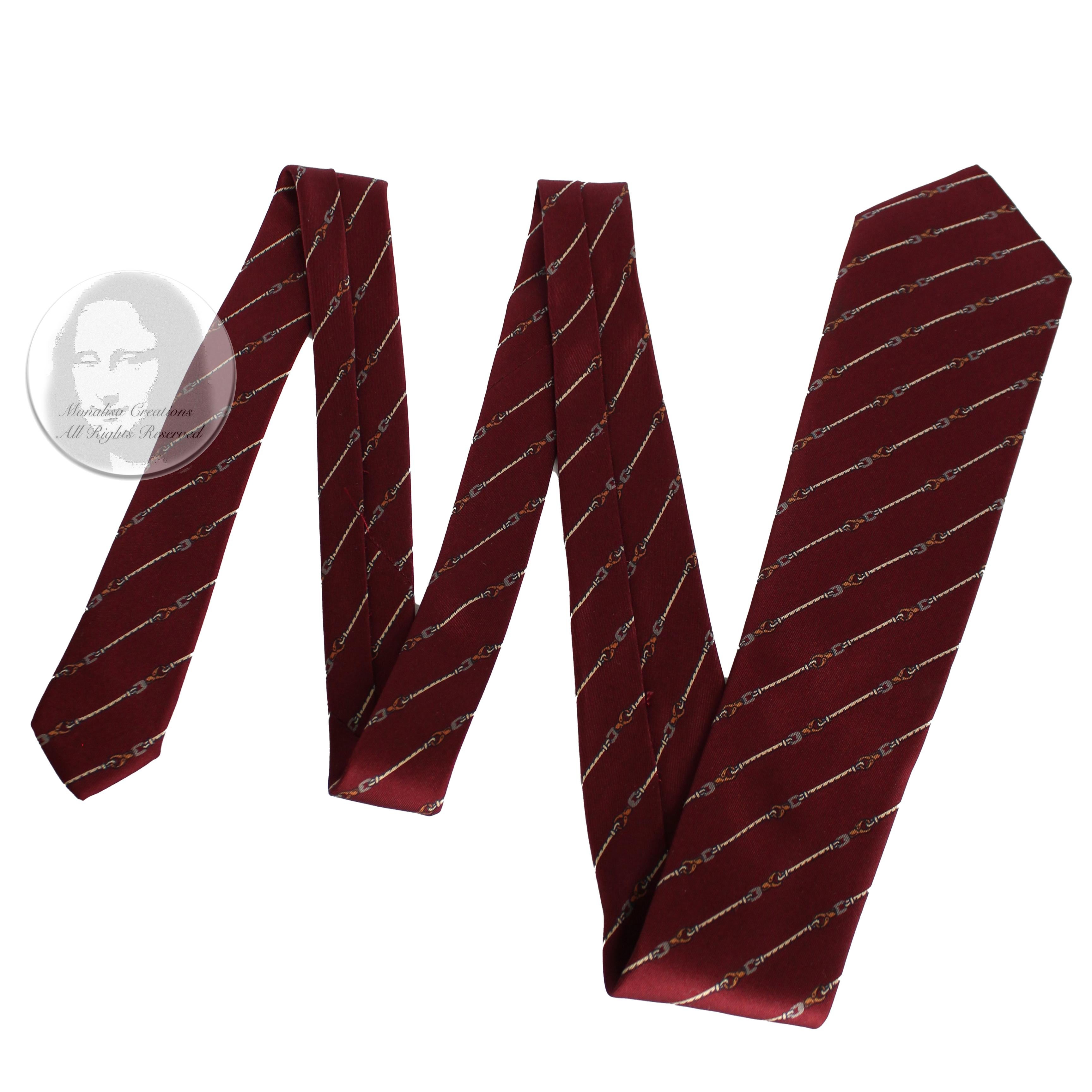 Preowned, authentic, vintage Gucci men's necktie, likely made in the 1970s. Made from silk, it features an understated yet classic horse bit print against a brick red background.  

A wonderfully stylish necktie from luxury fashion house Gucci in a