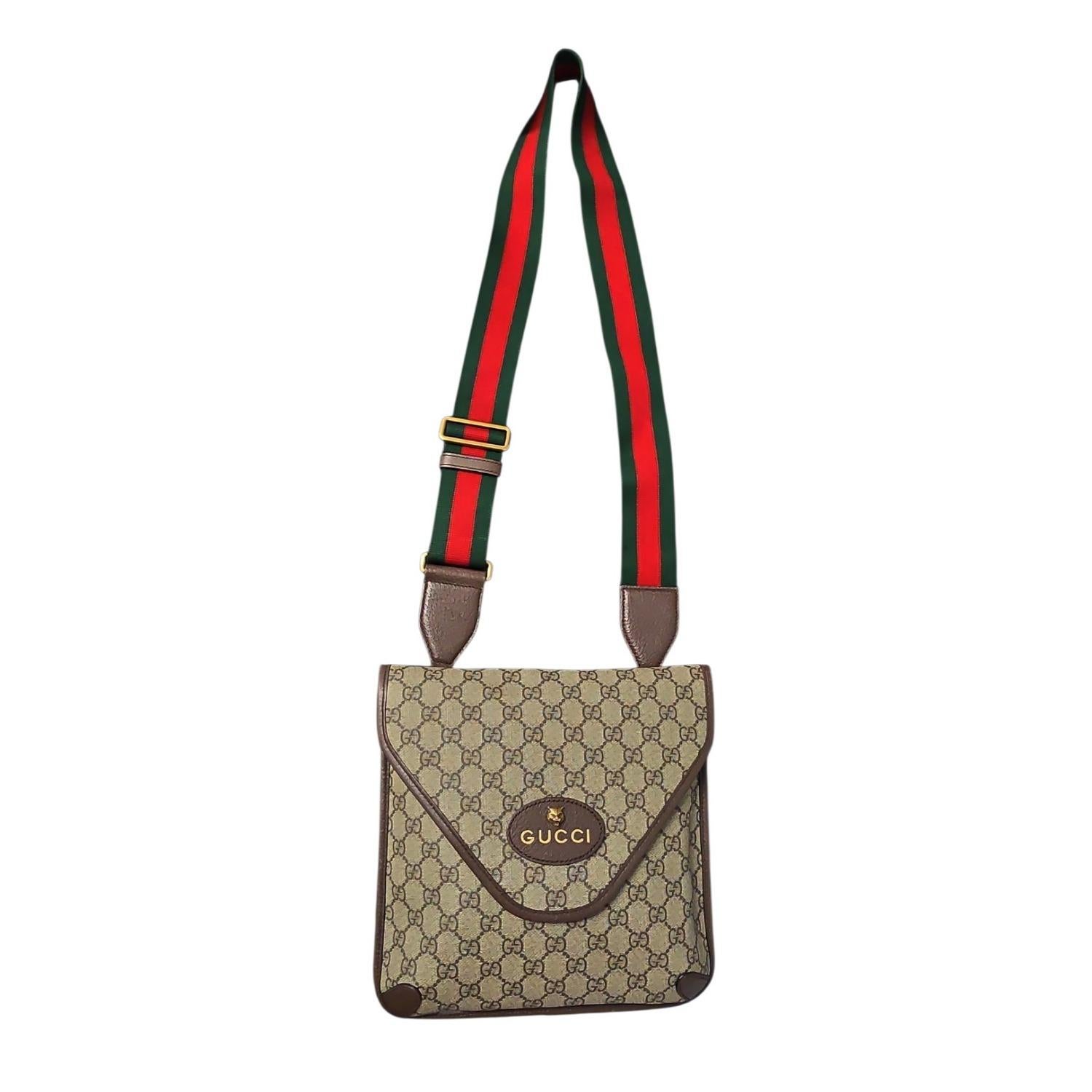 Esta elegante bandolera está confeccionada en lona revestida con el monograma Gucci GG en marrón clásico sobre beige, con ribetes de piel marrón oscuro y una etiqueta Gucci ovalada con una cabeza de tigre de latón en la parte delantera. El bolso