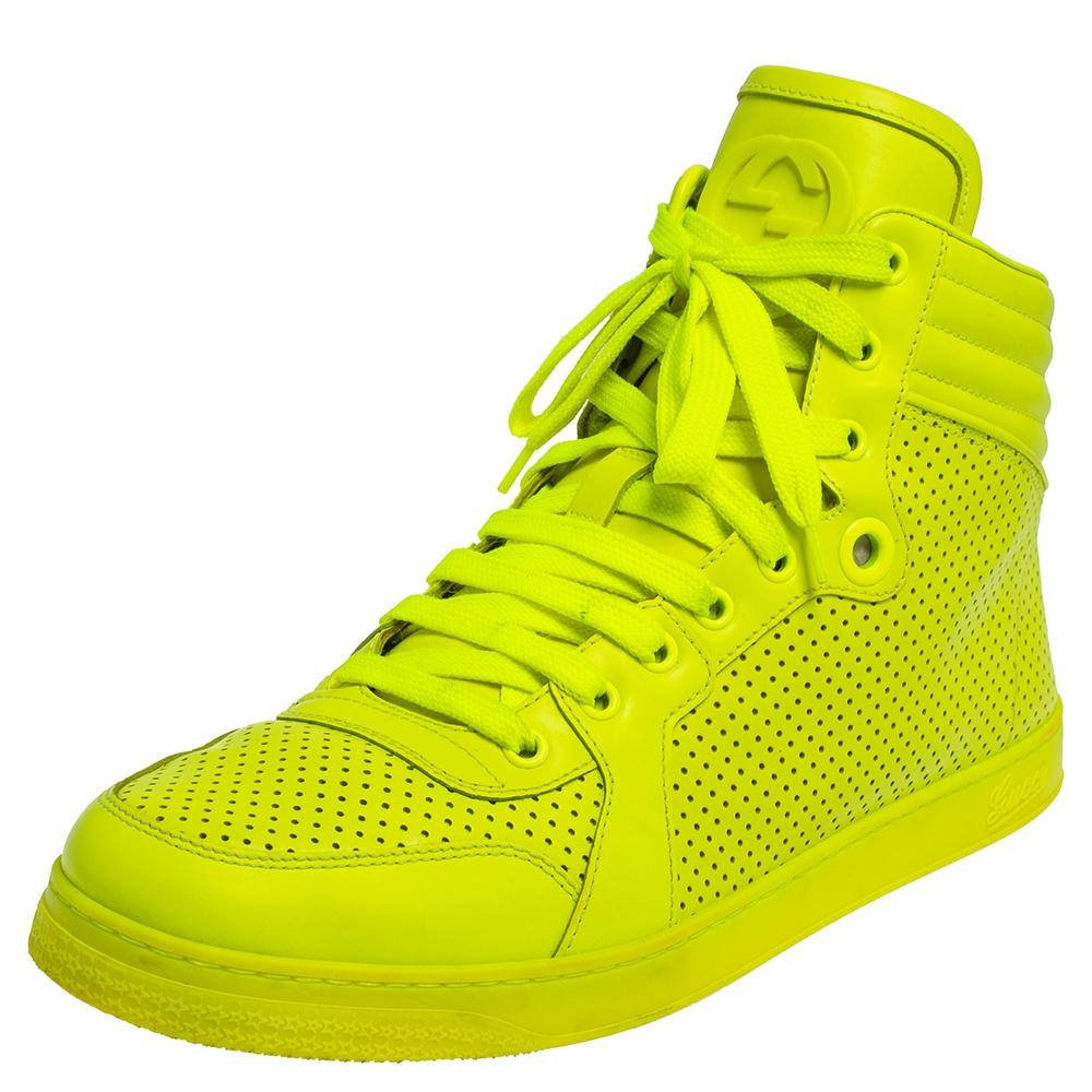 These stylish high-top sneakers by Gucci have been crafted in Italy. They are made of quality leather with a perforated design all over. They flaunt a neon green hue and are styled with lace-up fronts, signature GG logo on the tongue, leather