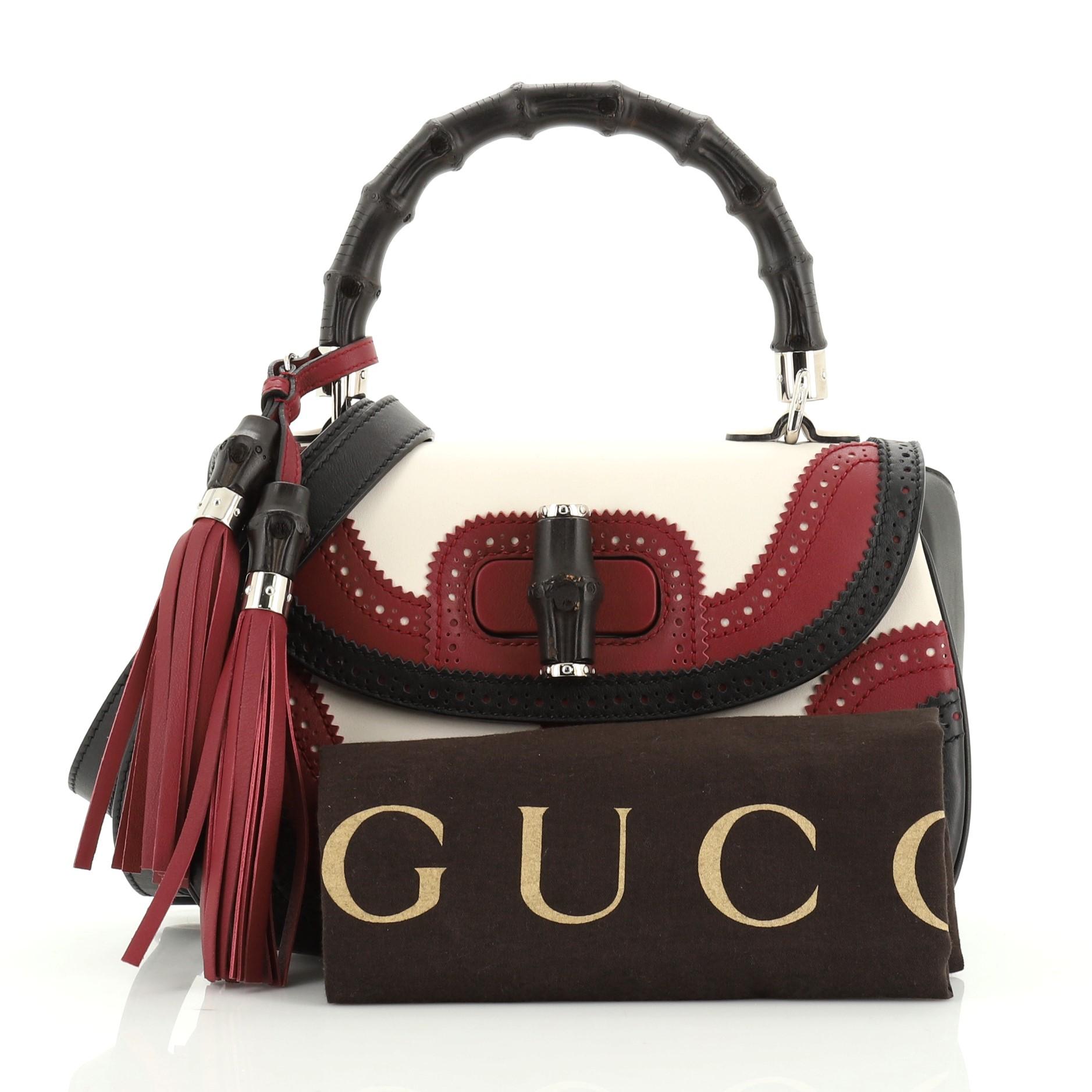 This Gucci New Bamboo Convertible Top Handle Bag Leather Medium was first designed in 1947, created out of burnishing cane sticks. Crafted in white, red and multicolor leather, it features a bamboo top handle, leather trim and silver-tone hardware.