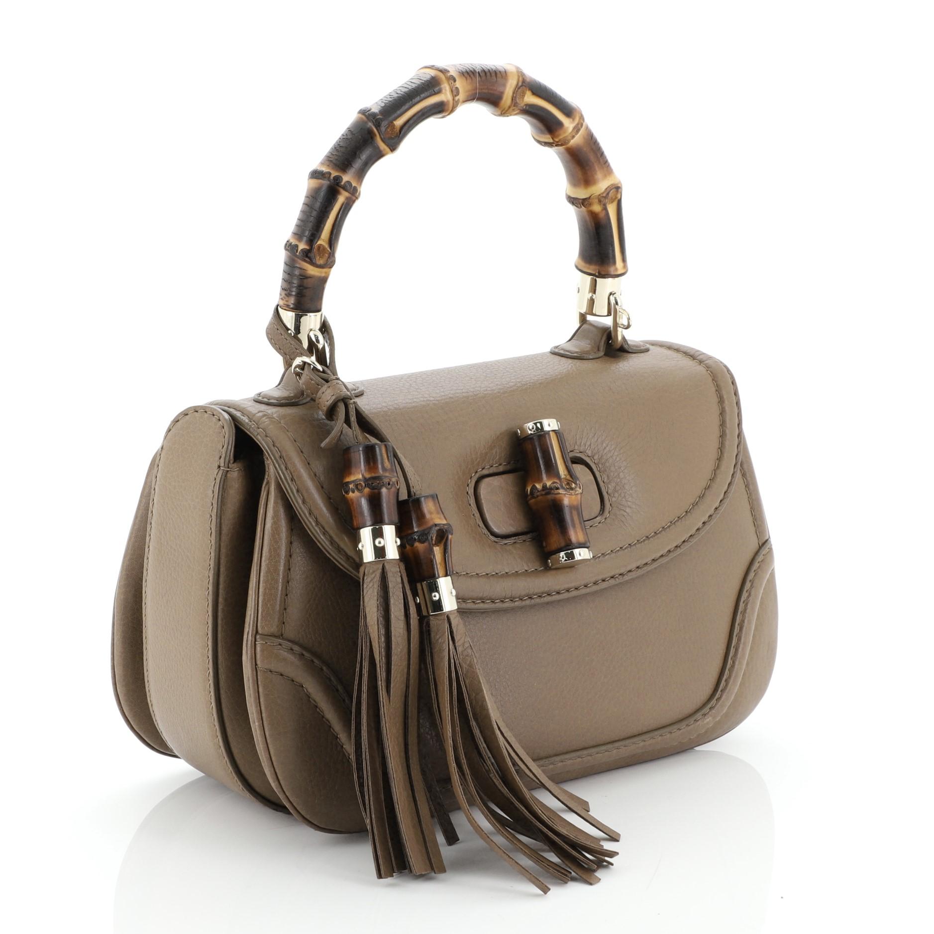 This Gucci New Bamboo Convertible Top Handle Bag Leather Medium, crafted in neutral leather, features a bamboo top handle, leather trim and gold-tone hardware. Its bamboo turn-lock closure opens to a neutral fabric interior with side zip and slip