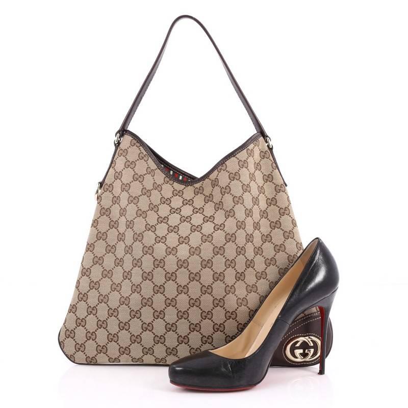 This authentic Gucci New Britt Hobo GG Canvas Medium is perfect for any casual or sophisticated outfit. Constructed from brown GG canvas with chocolate brown leather trims, this lightweight shoulder bag features GG interlocking logo, flat leather