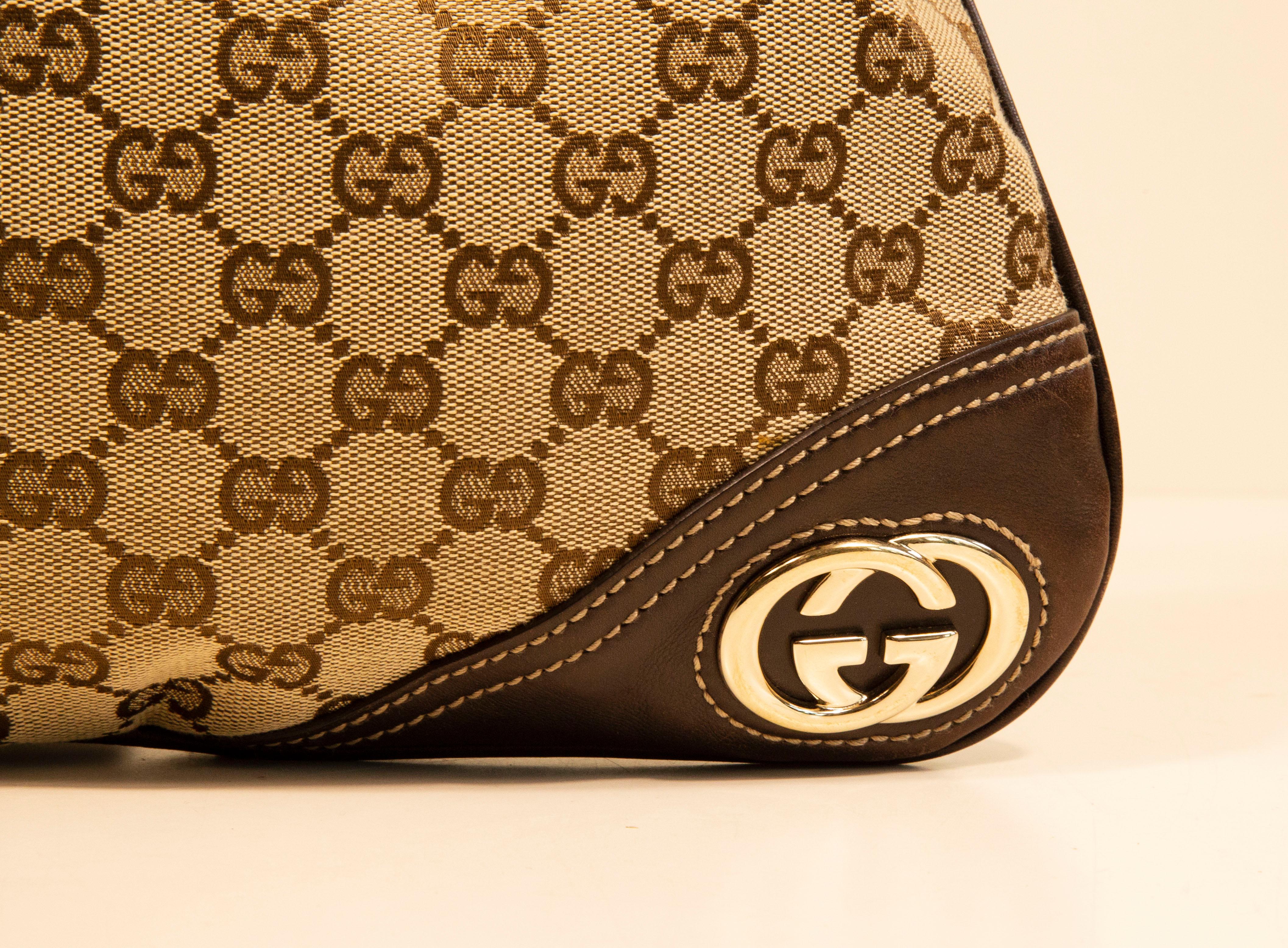 A Gucci New Britt hobo bag/shoulder bag made of GG Guccissima canvas with brown leather trim and light gold toned hardware such a GG interlocking logo in the front left bottom corner. The interior is lined with fabric in green, red, and white