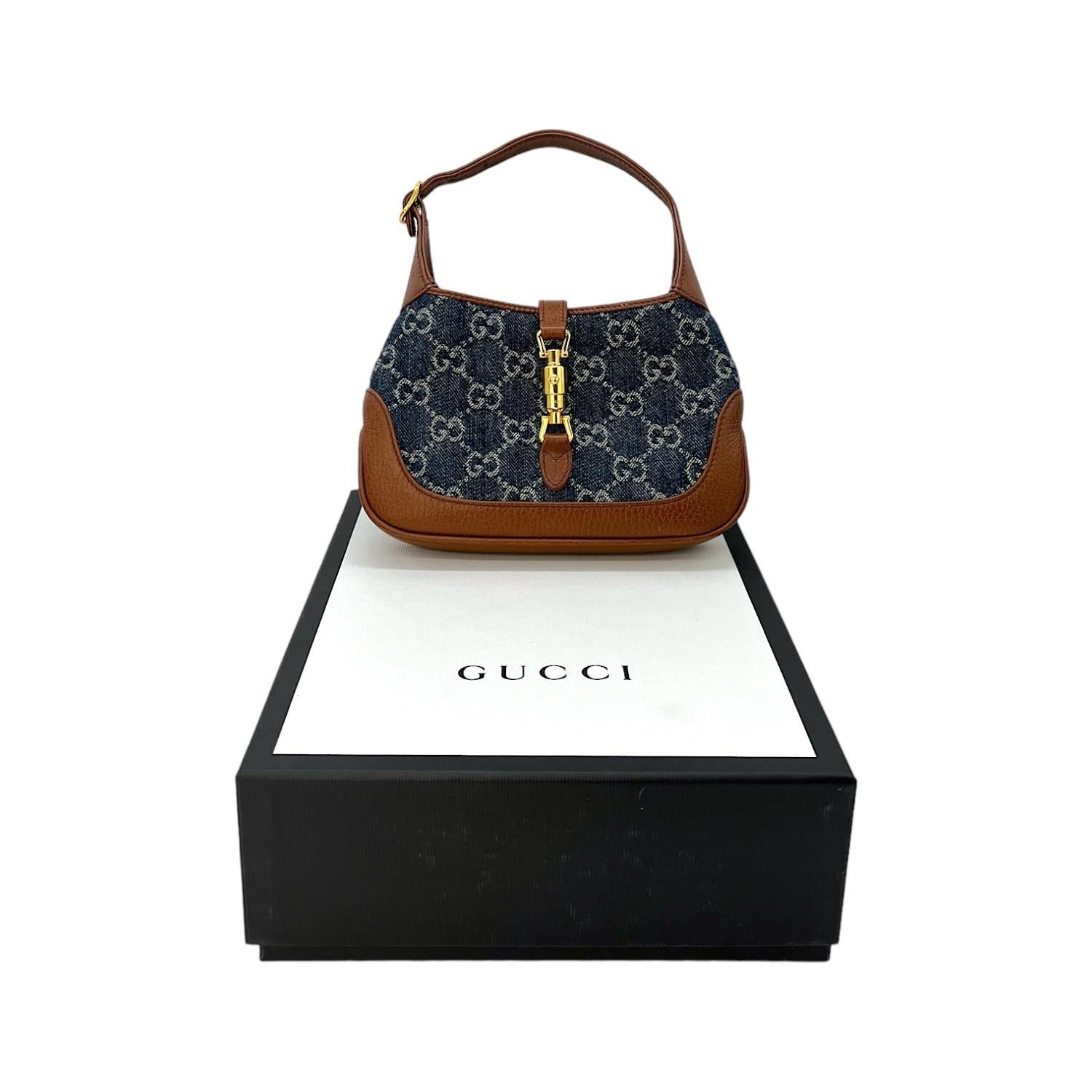 This Gucci Mini Jackie 1961 Hobo was made in Italy and it is finely crafted of Gucci GG Monogram denim with calfskin leather trimming and gold-tone hardware features. It has a flat leather handle and it also comes with a flat leather strap that you