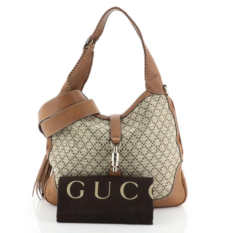 This Gucci New Jackie Bag Diamante Canvas Medium, crafted from neutral diamante canvas and leather, features adjustable shoulder strap, whipstitch strap detailing, and gold-tone hardware. Its piston strap closure opens to a neutral fabric interior