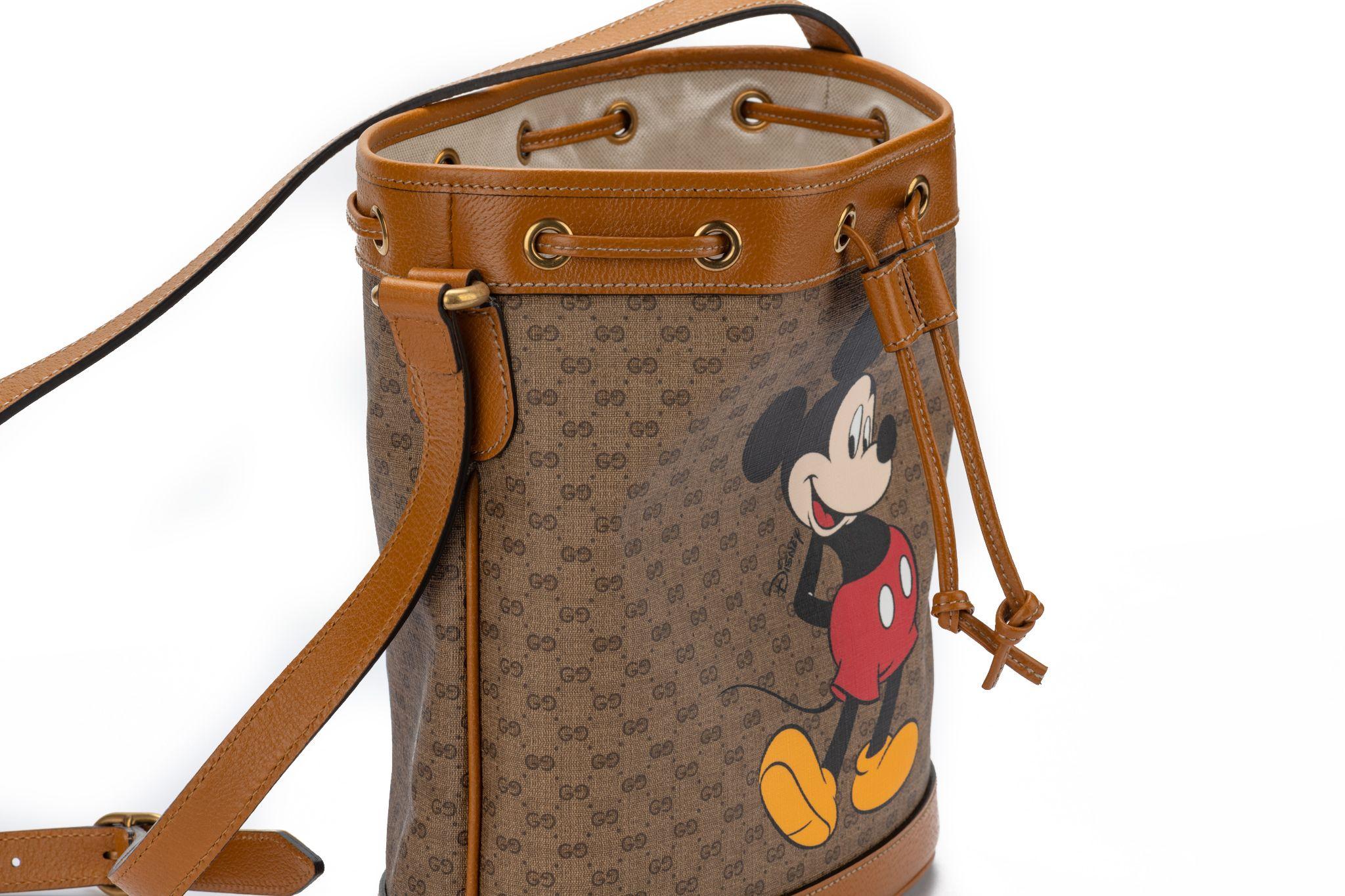 Gucci Disney bucket bag featuring a print of a Mickey Mouse. The bag comes with an adjustable shoulder strap measures 22”. Its new and comes with booklets and original dustcover.