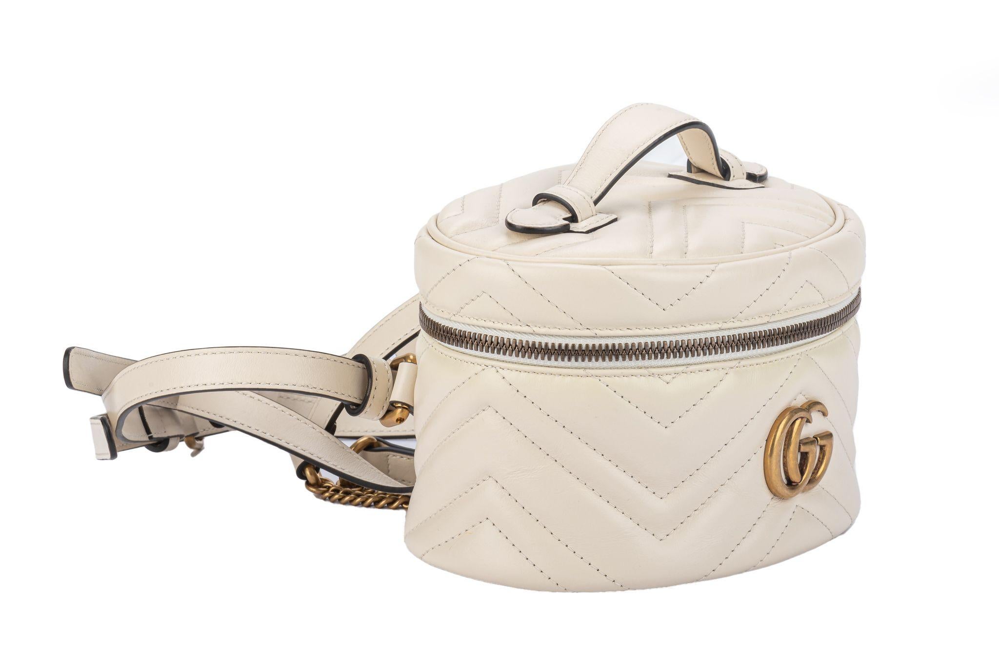 Gucci new mini Marmont backpack in cream leather with bronze hardware. Top handle, adjustable straps and original dust cover. Fits a phone.
