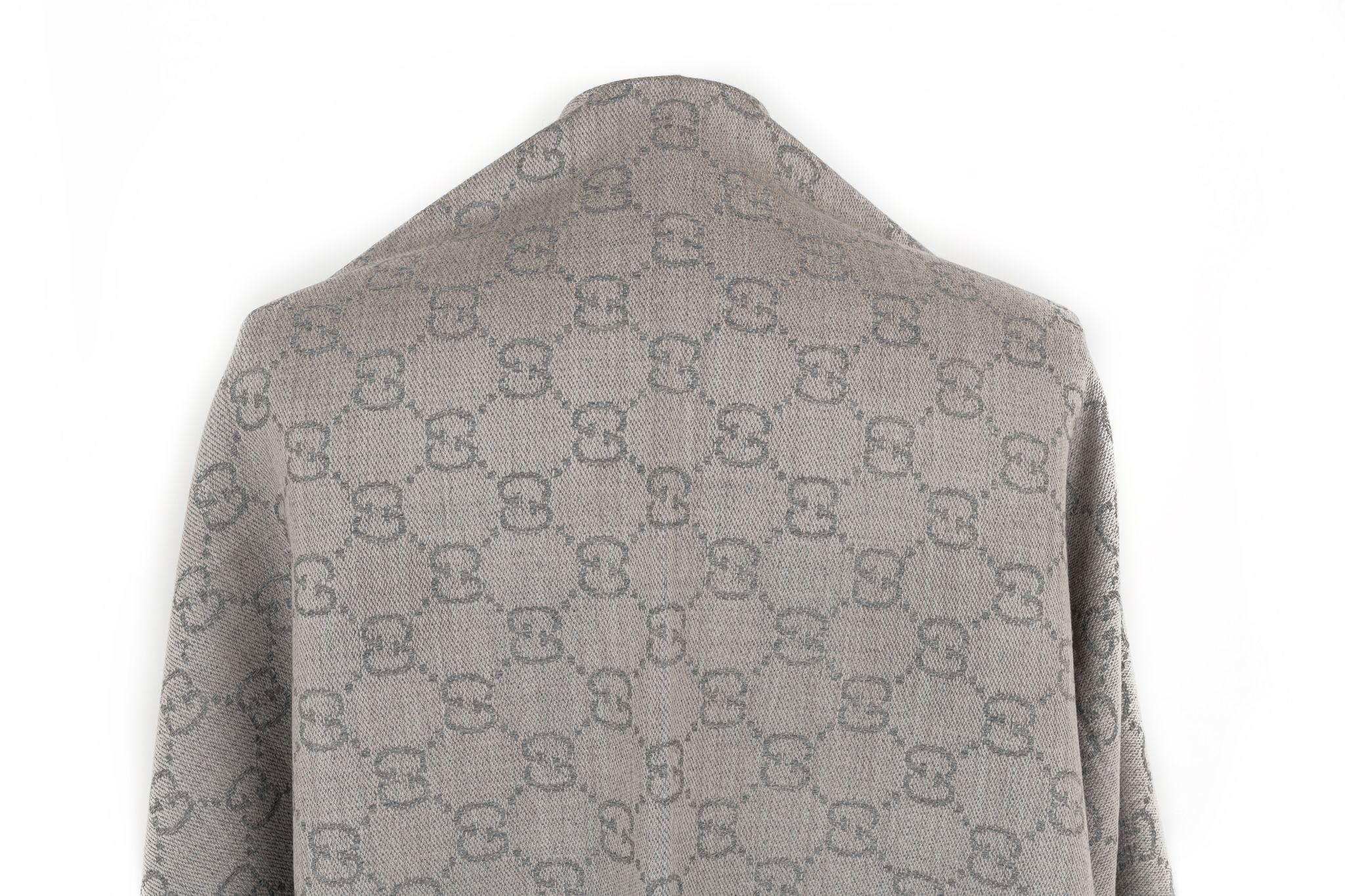 Gucci wool shawl in grey with a GG monogram logo canvas print. The piece is in new condition.