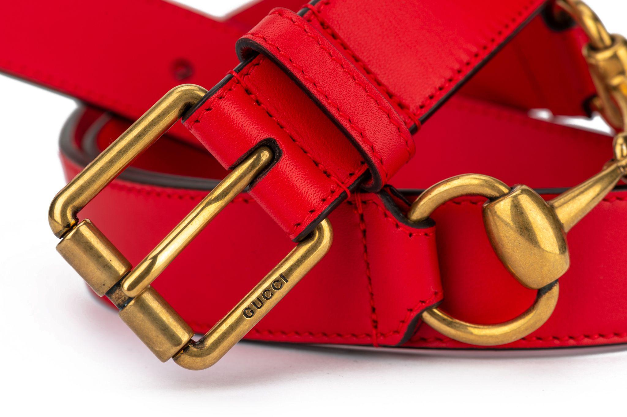 Cintura media in pelle rossa brillante nuova di zecca di Gucci con dettaglio frontale in oro spazzolato a forma di cavallo. 
100cm/41.5