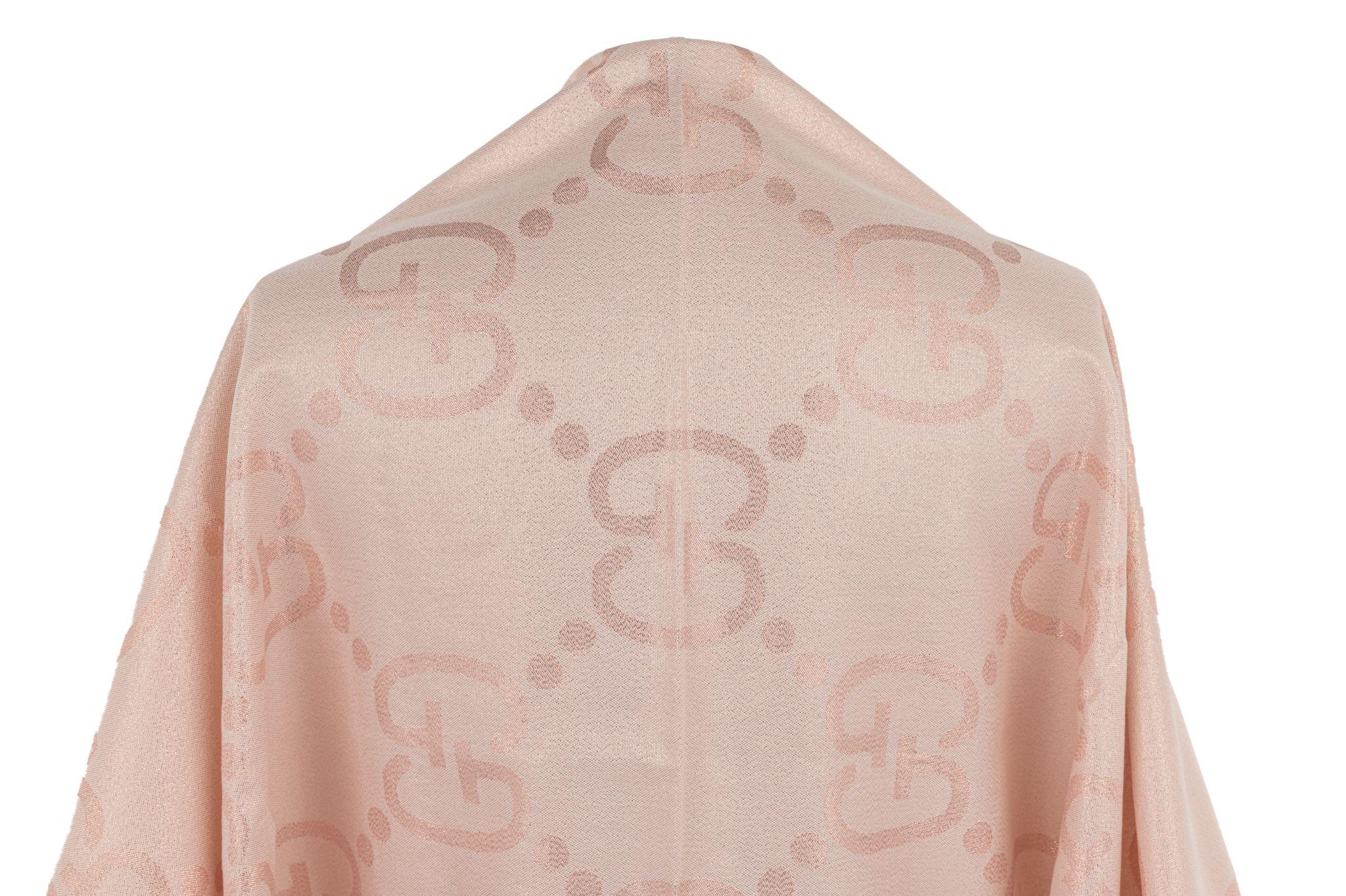 Gucci silk-blend shawl with the pattern of big GG logos. The metalized fiber in the fabric gives the piece a little bit of a shine. The item is in excellent condition with little damage on the trim.