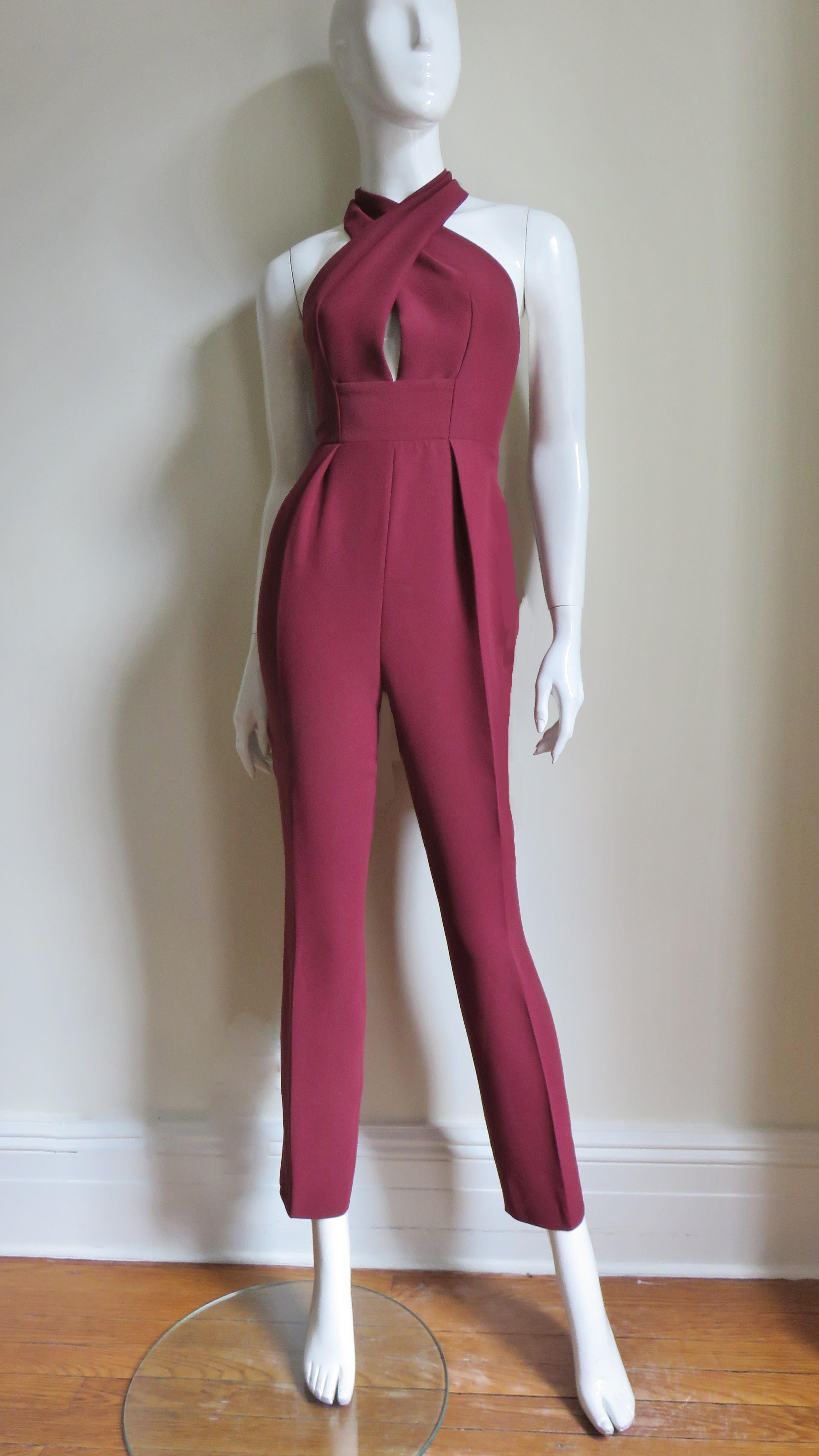 A fabulous deep red silk jumpsuit from Gucci.  It has a  halter neckline crossing at the front then wrapping around the neck. There is a band at the waist and the pants portion are straight leg.  It is unlined with a back zipper and matching mother