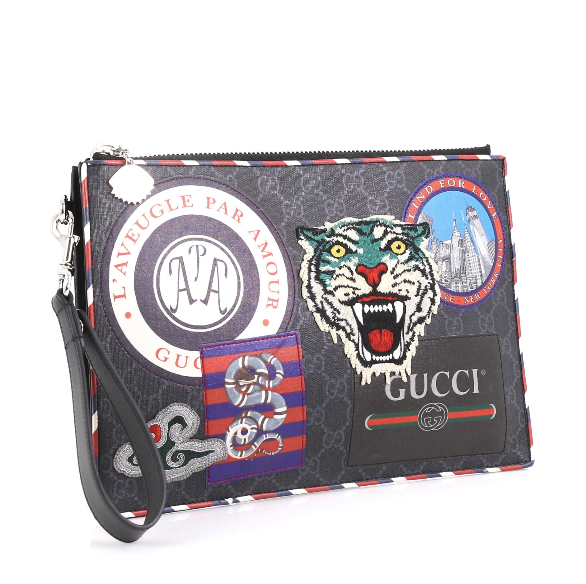 This Gucci Night Courrier Pouch GG Coated Canvas with Applique, crafted from blue GG coated canvas and leather with applique, features leather wrist strap and silver-tone hardware. Its zip closure opens to a black fabric interior with multiple card