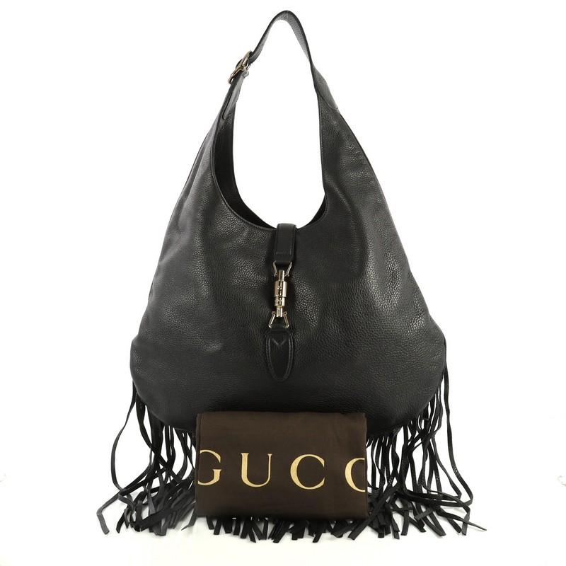 This Gucci Nouveau Fringe Jackie Hobo Leather, crafted in black leather, features an adjustable leather handle, cascading fringes at the bottom edges and gunmetal-tone hardware. Its piston lock closure opens to a neutral leather interior with side
